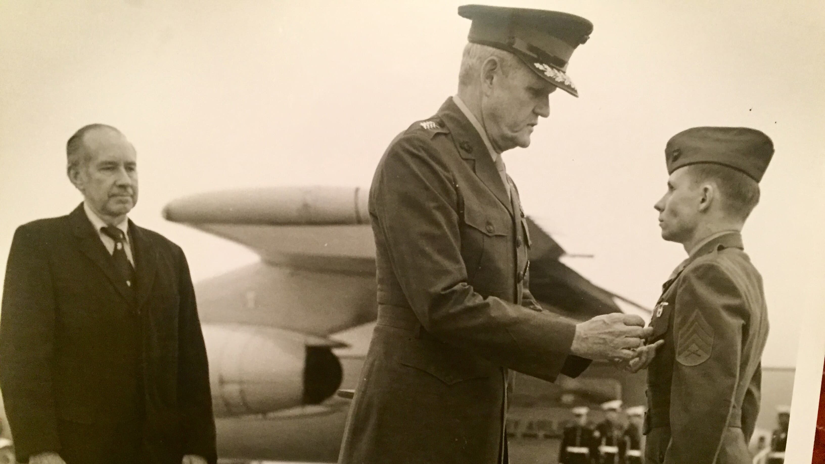Ken Kraus receives a medal in front of an airplane