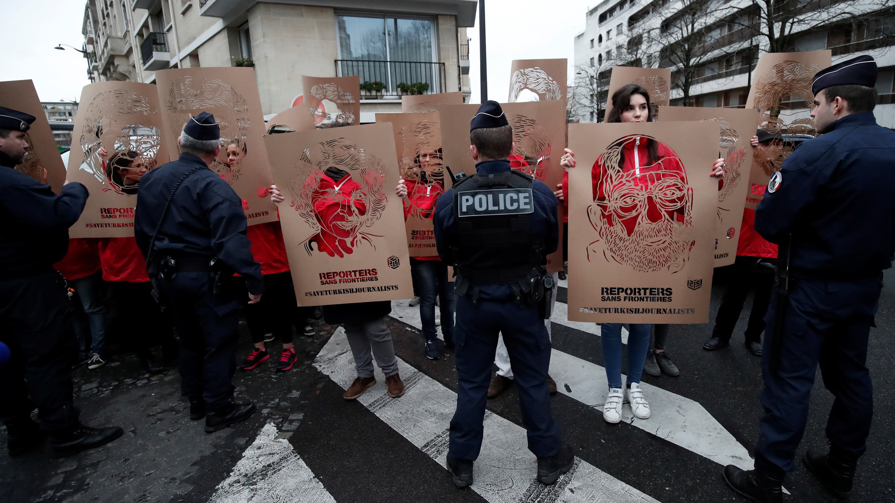Members of Reporters Without Borders (RSF) hold stencils made by French street artist C215 representing portraits of emprisonned Turkish journalists,