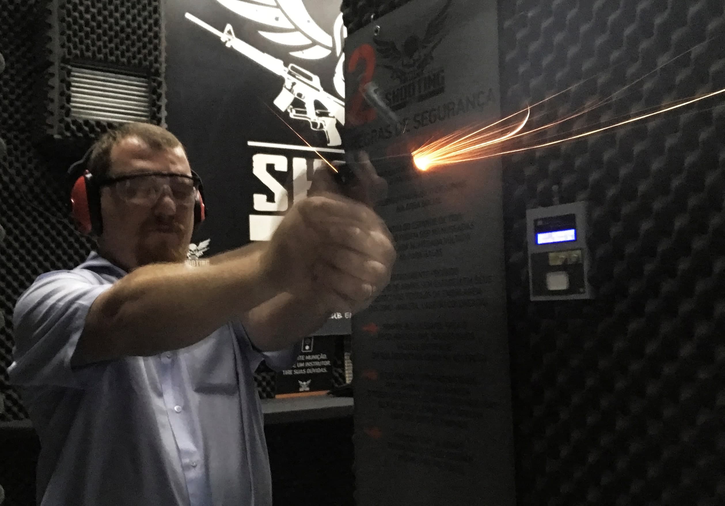 A man fires a handgun in a shooting range