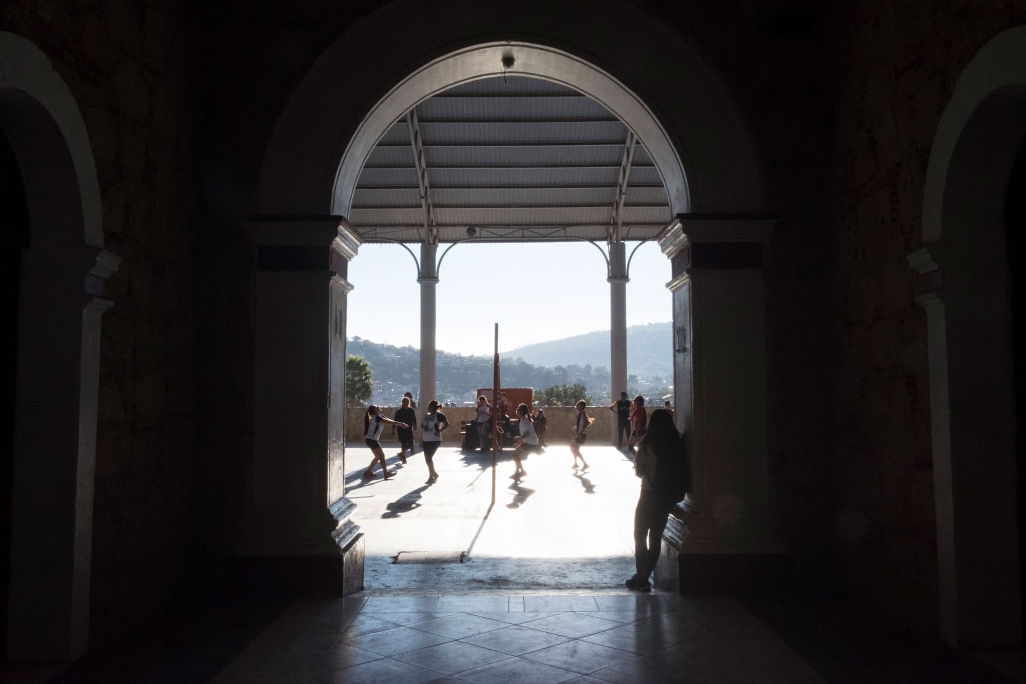 Women are shown playing volleyball in the distance.