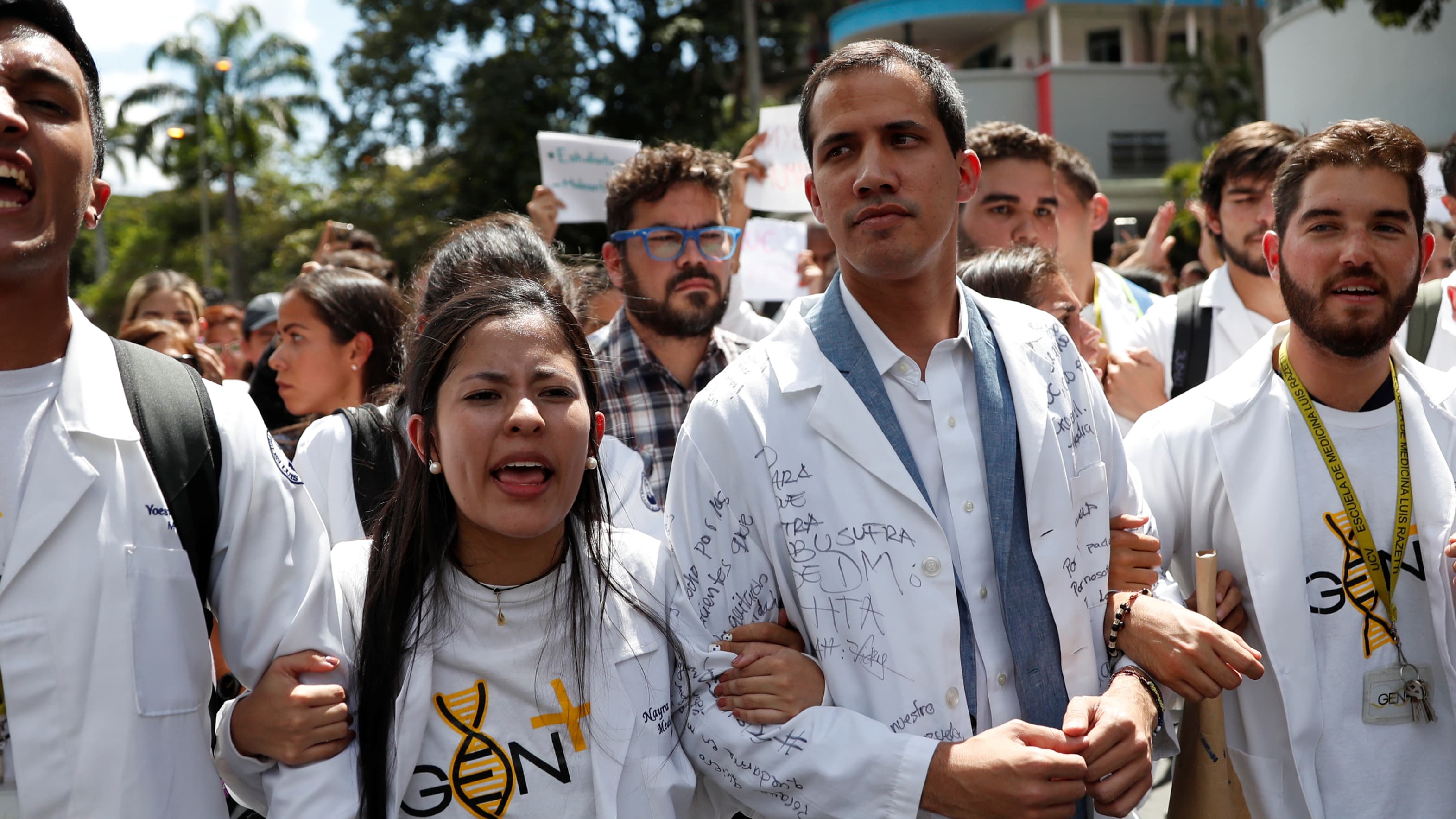 Protesters walk in white with interim President Juan Guaidó.