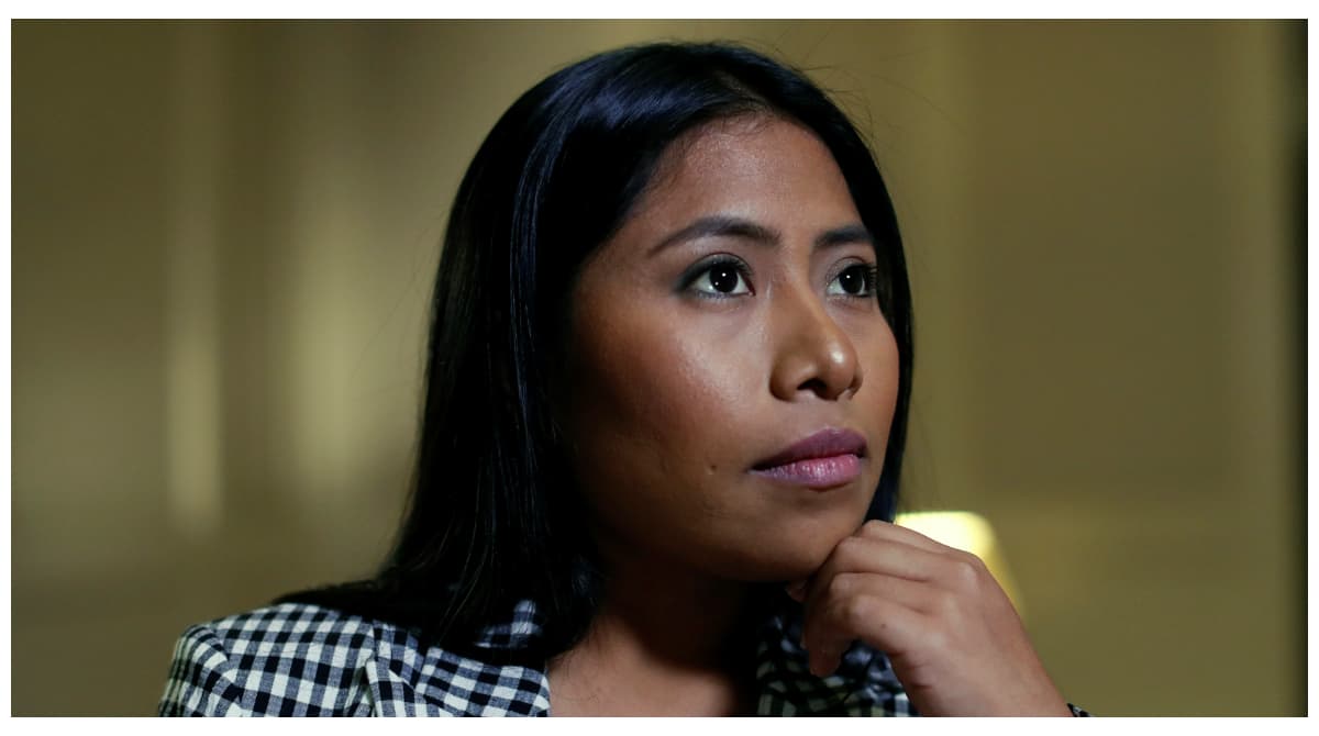 Yalitza Aparicio mira hacia un lado con su mano en el menton.