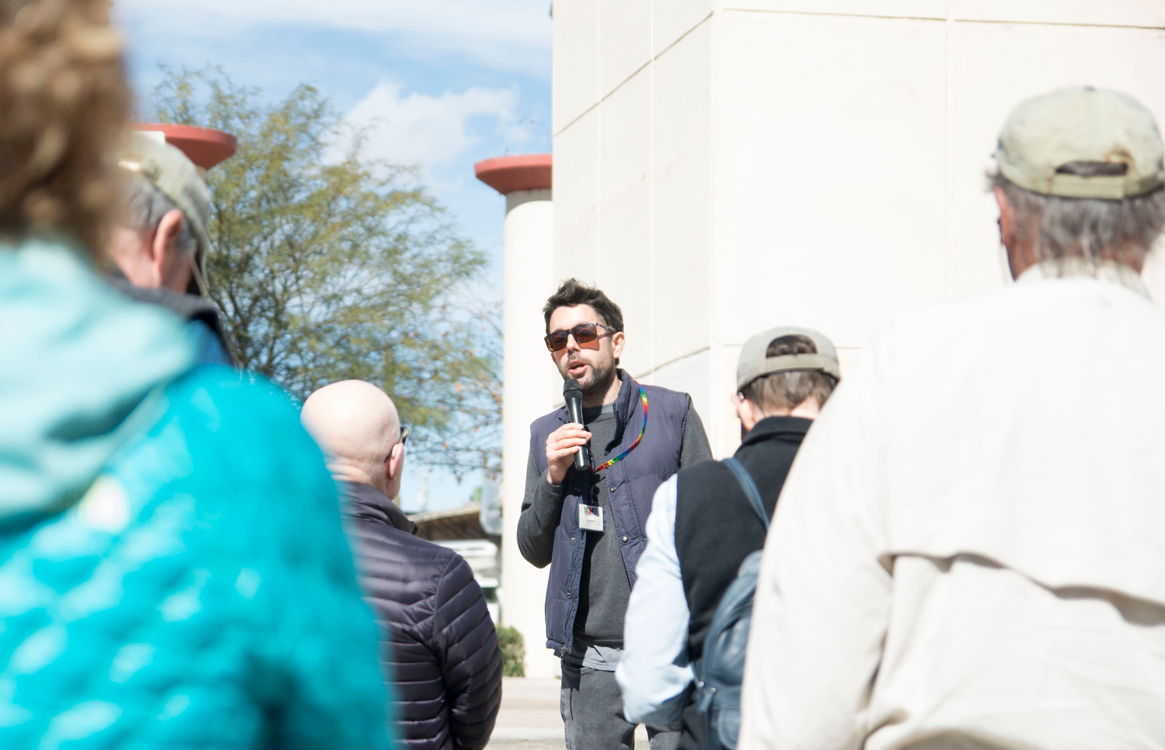 A man with a microphone talks to a small group