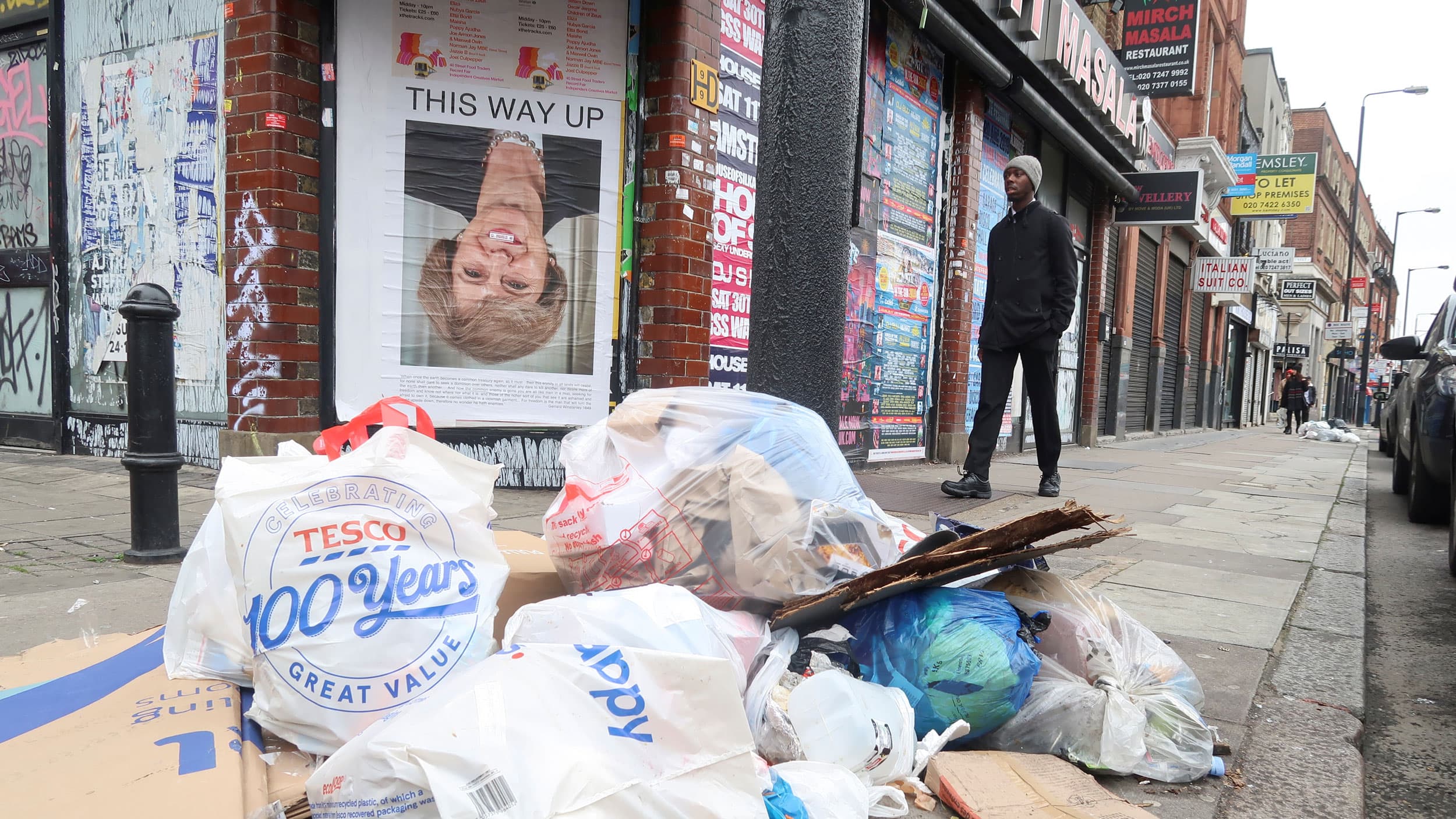 A poster with Theresa May is on a building upside down that reads "This way up"