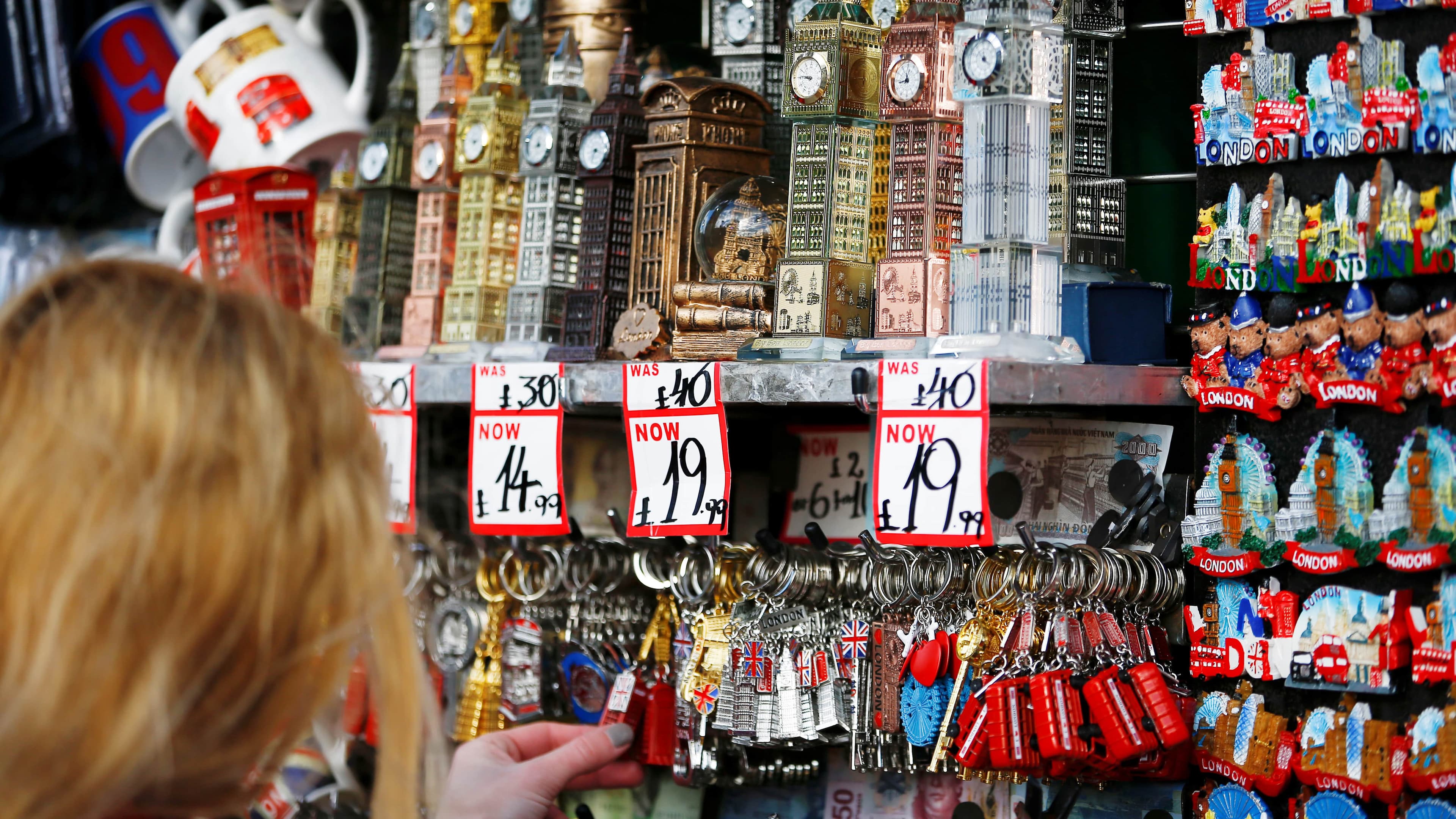 the back of a woman's head as she rifles through some British souvenir knick knacks