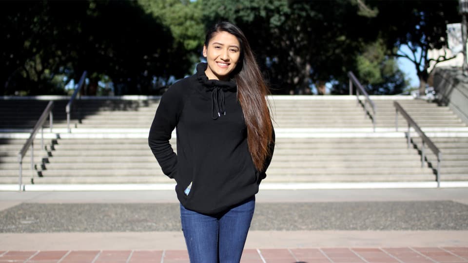 A young woman standing on campus.
