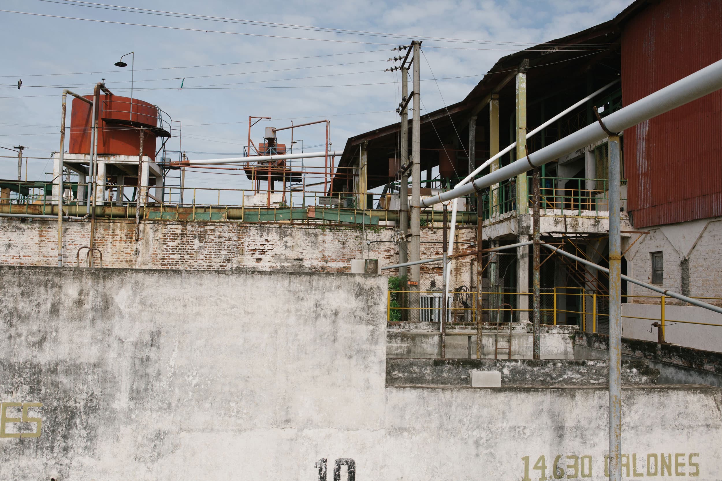 A wide shot photograph of several buildings connected to many pipes.