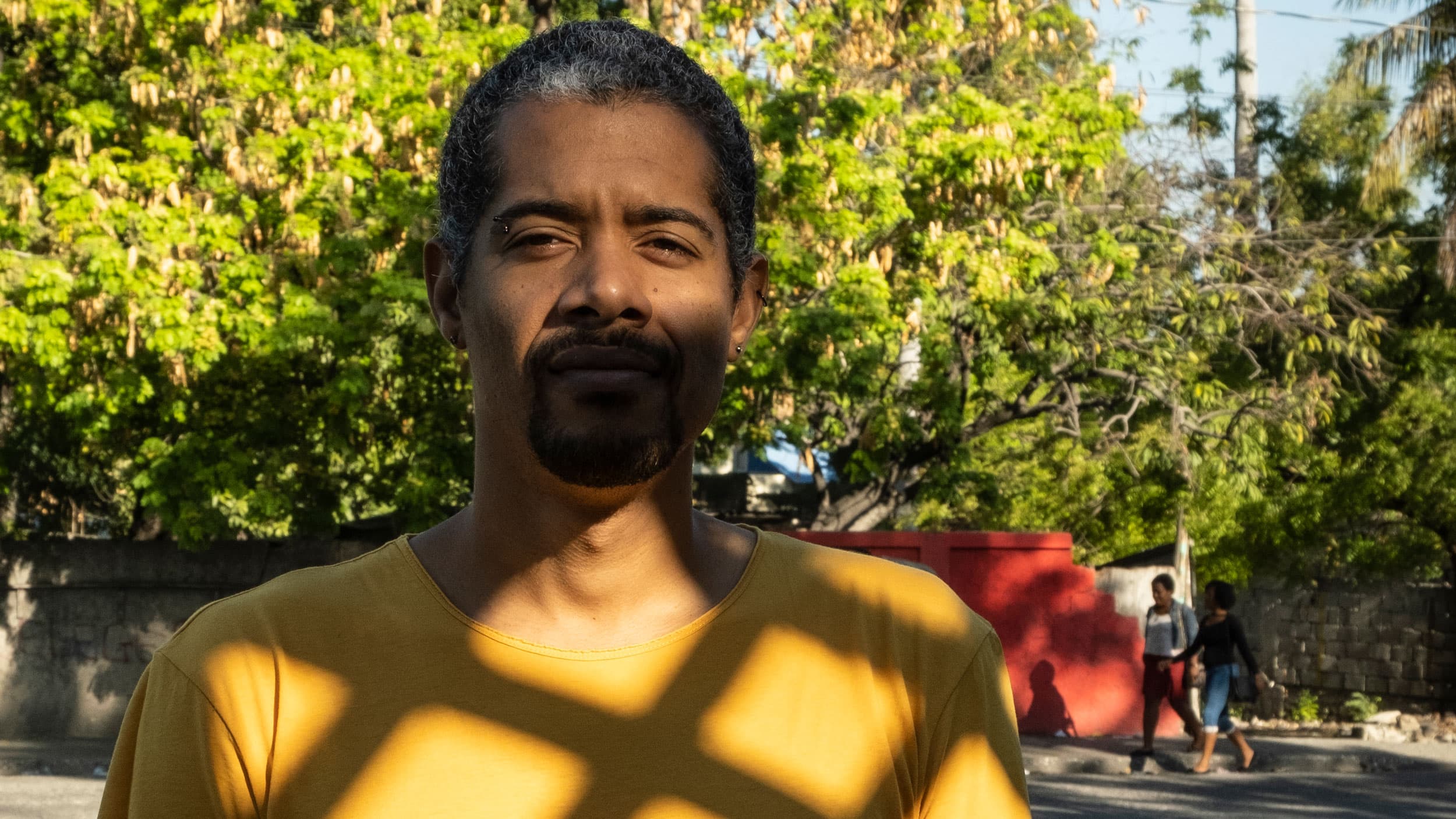 A portrait of Gilbert Mirambeau Jr., who is shown wearing a yellow t-shirt.