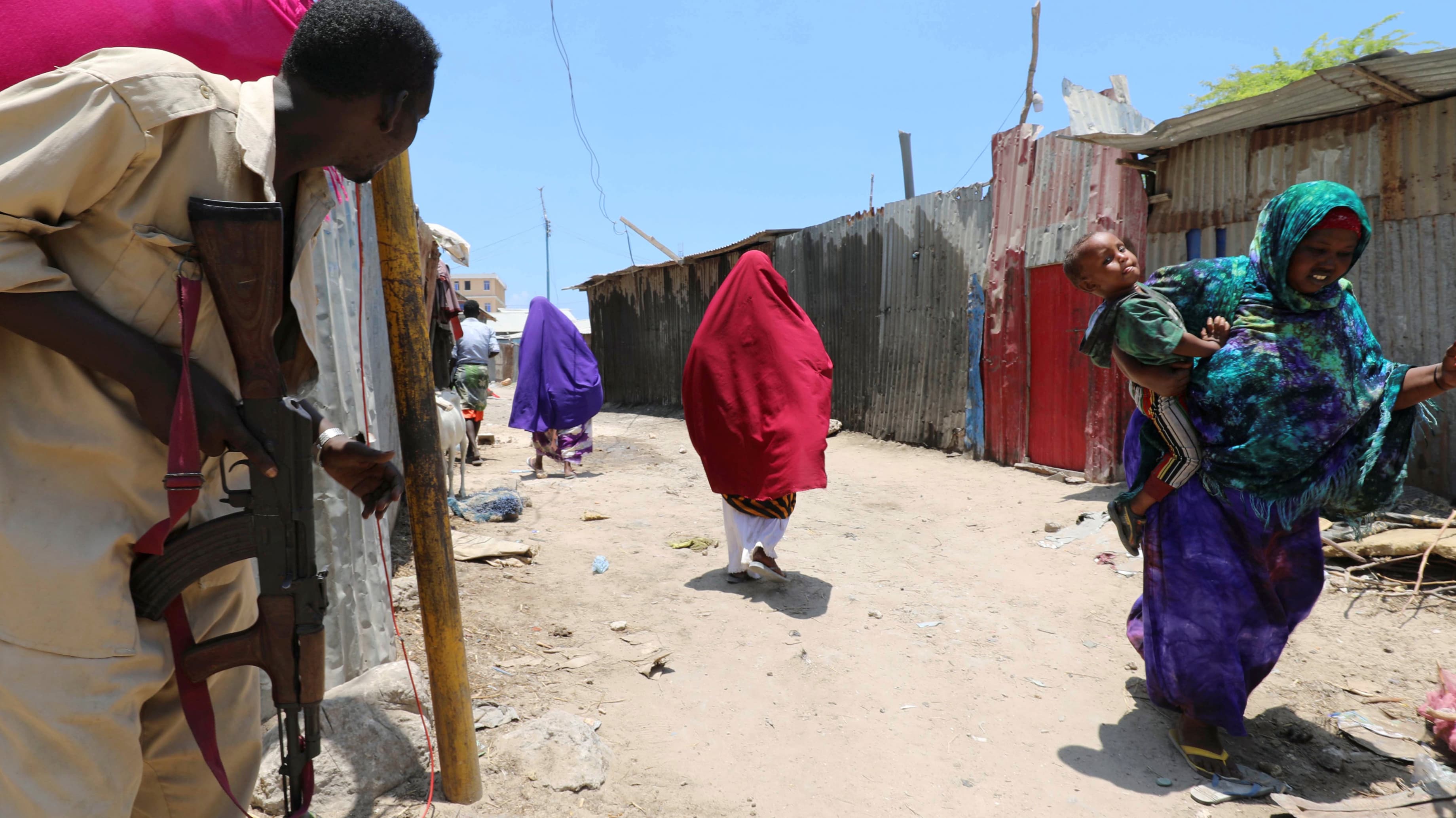 Women in colorful robes escape from building after explosion.