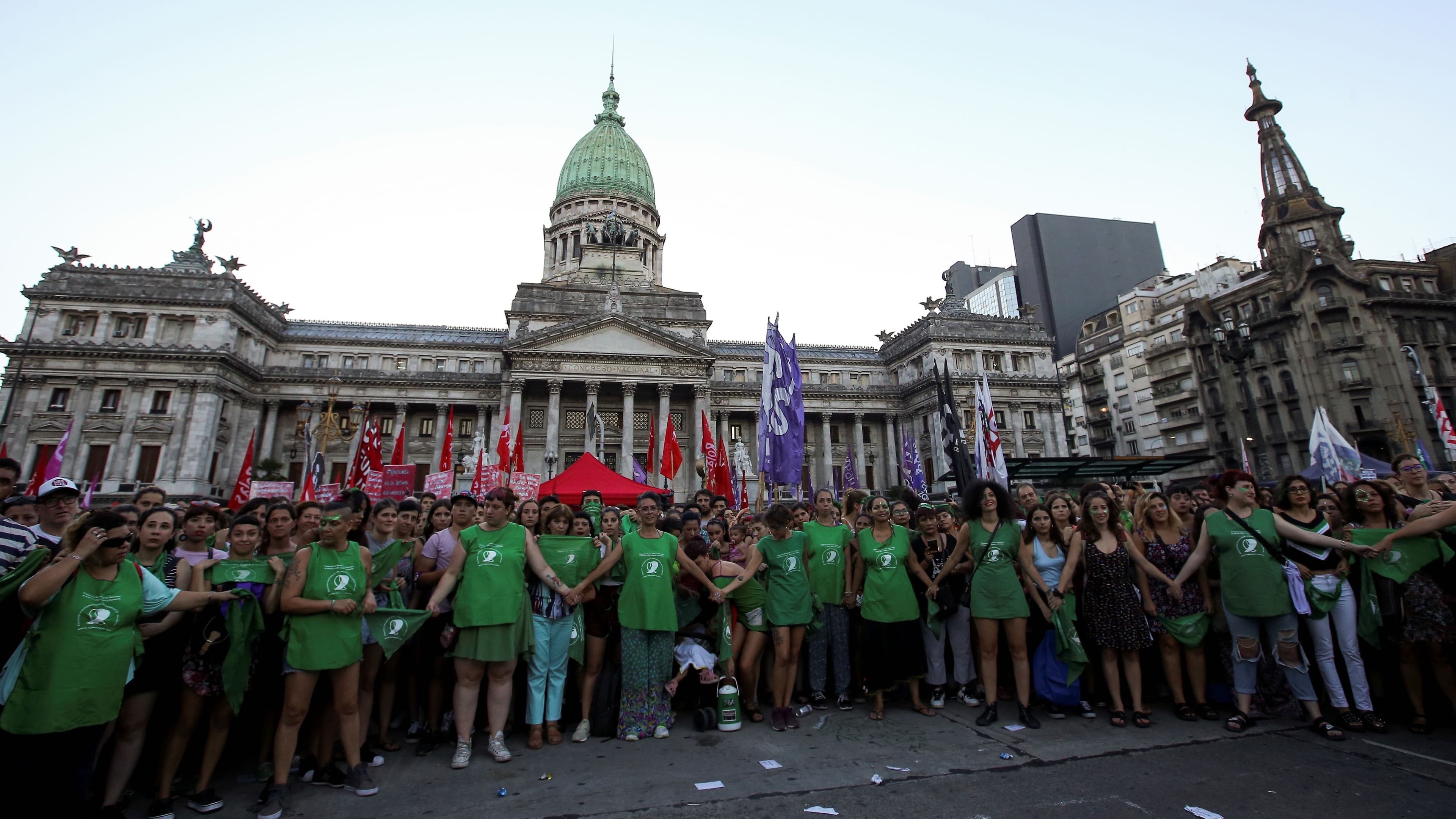 Activists hold hands outside the National Congress in Argentina.
