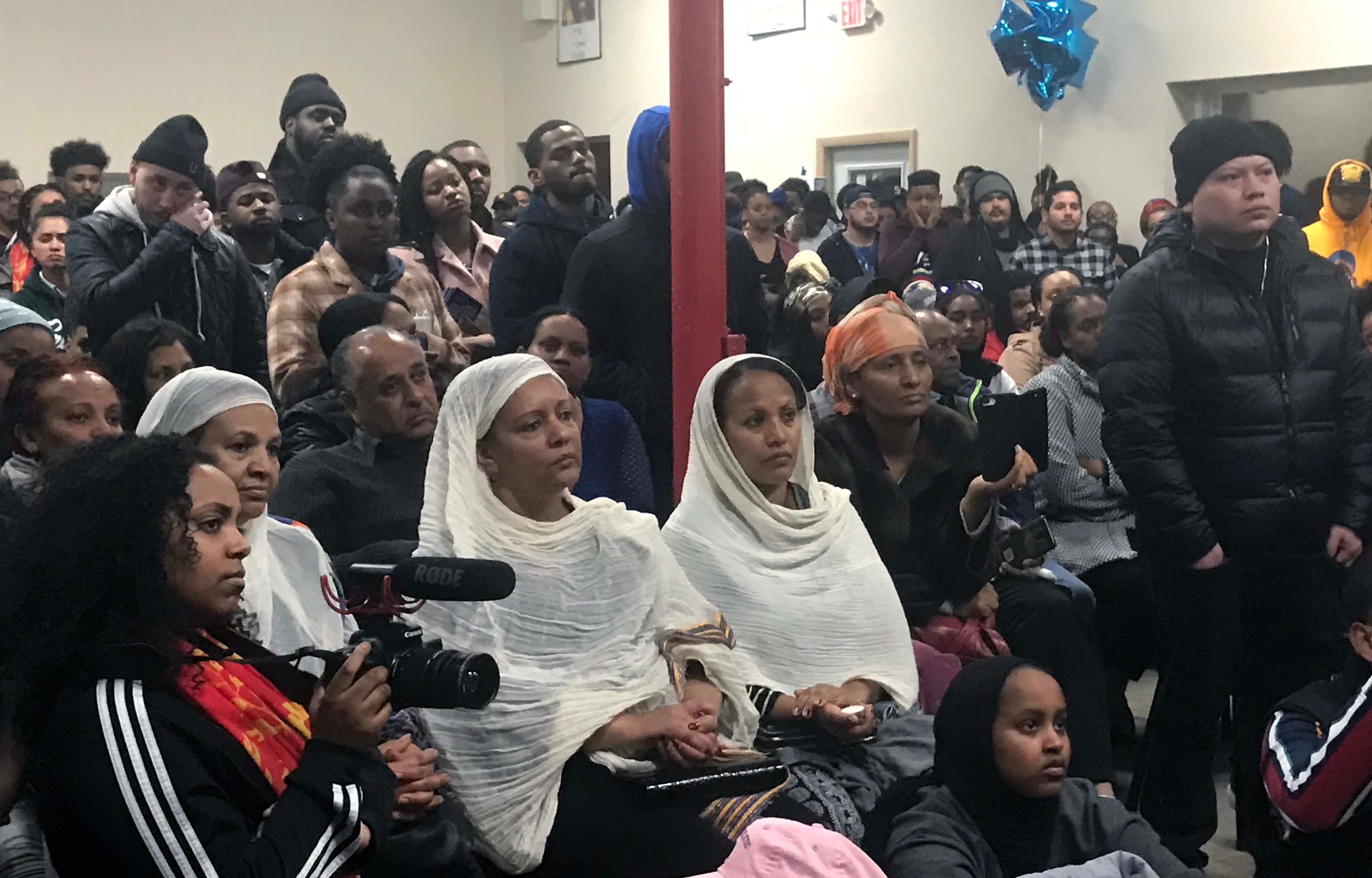 people sitting looking toward a stage.