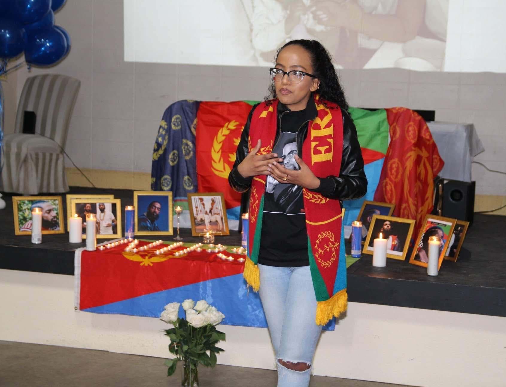 A woman stands in front of a make shift altar.