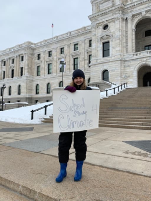 A young woman holds a sign