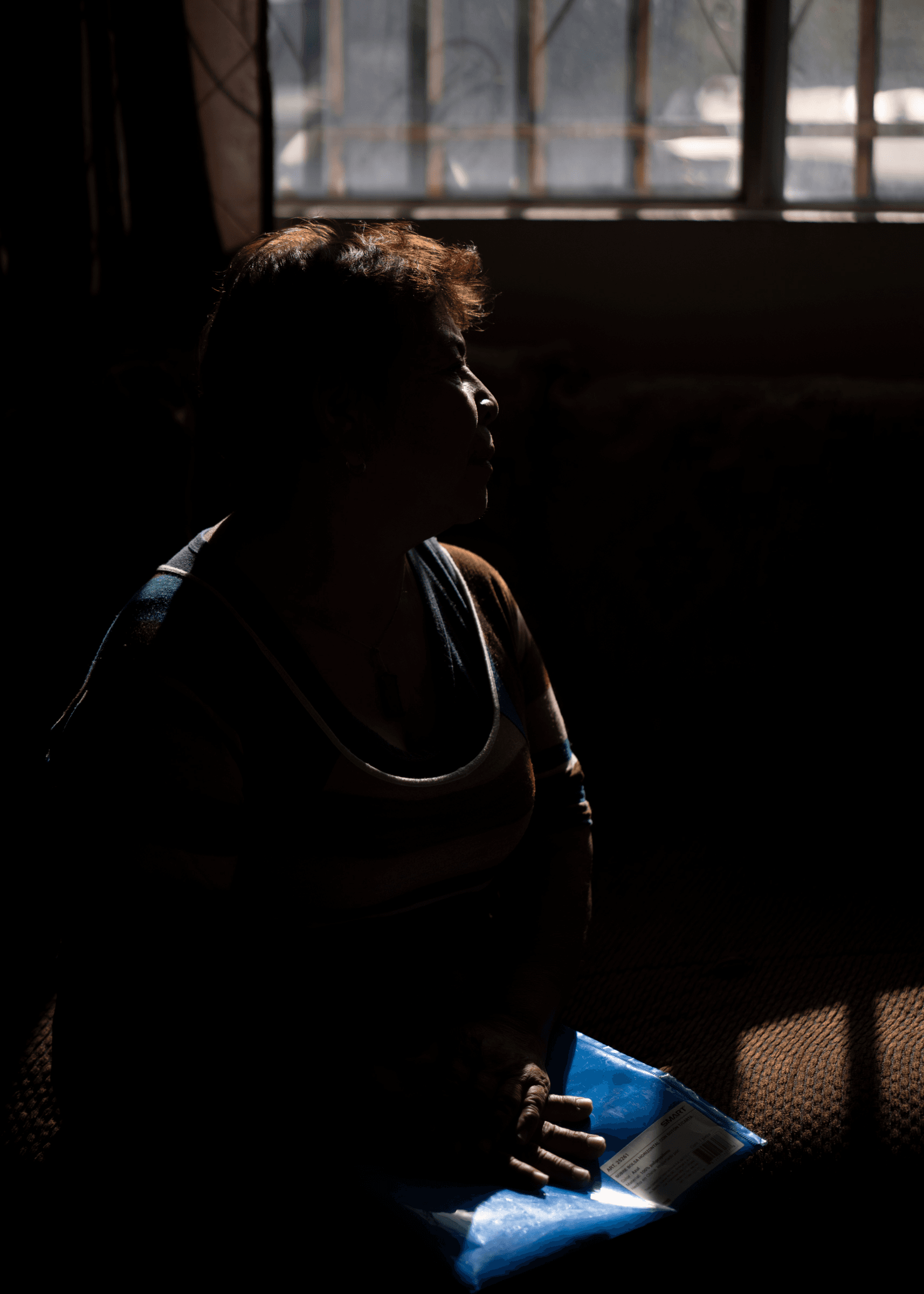 A woman sits with papers on her lap