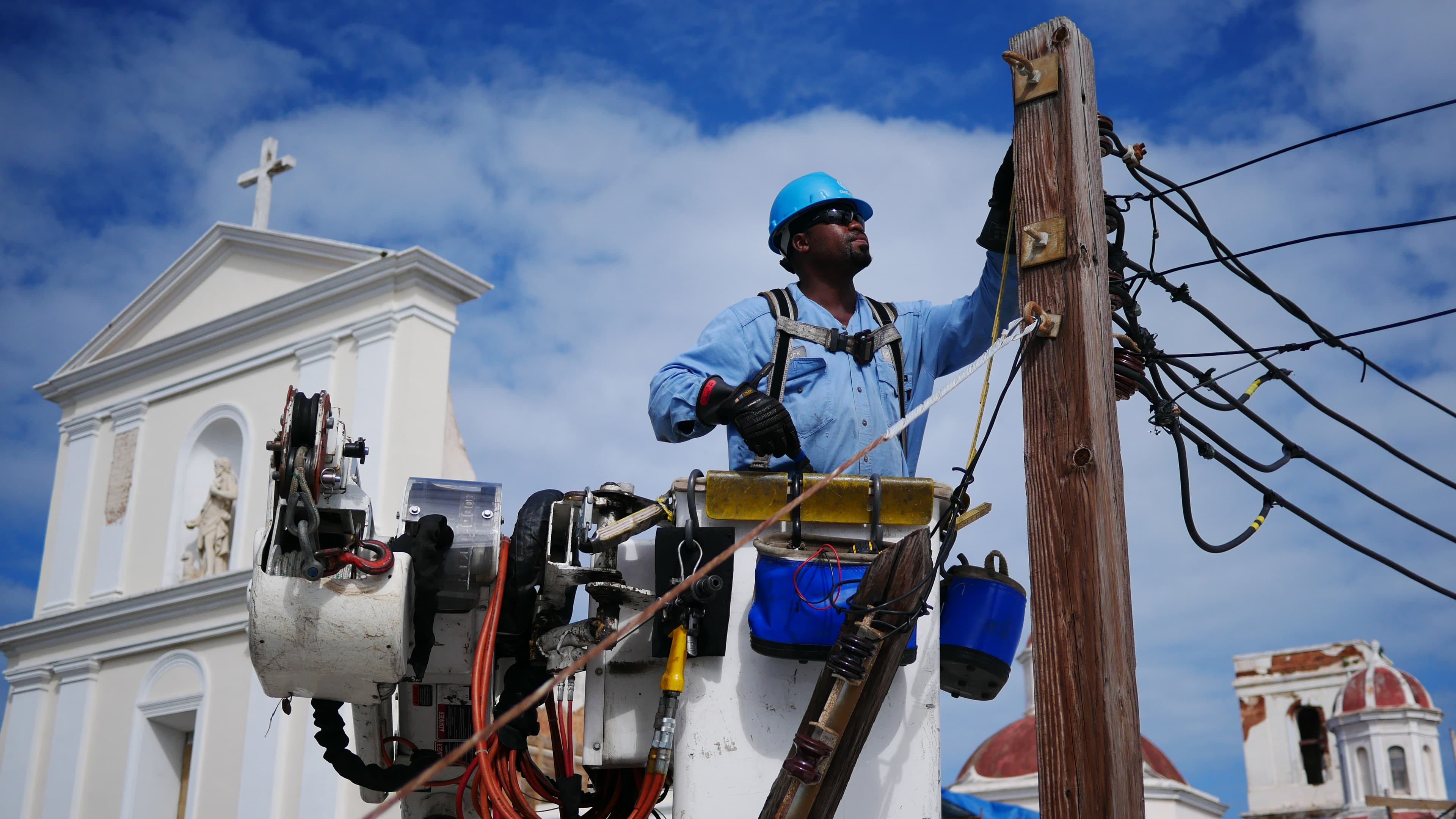 Marc Noisette of Westchester County, New York fixes the cables on an electric post opposite the Cathedral of San Juan in the historic quarter of Puerto Rico's capital.