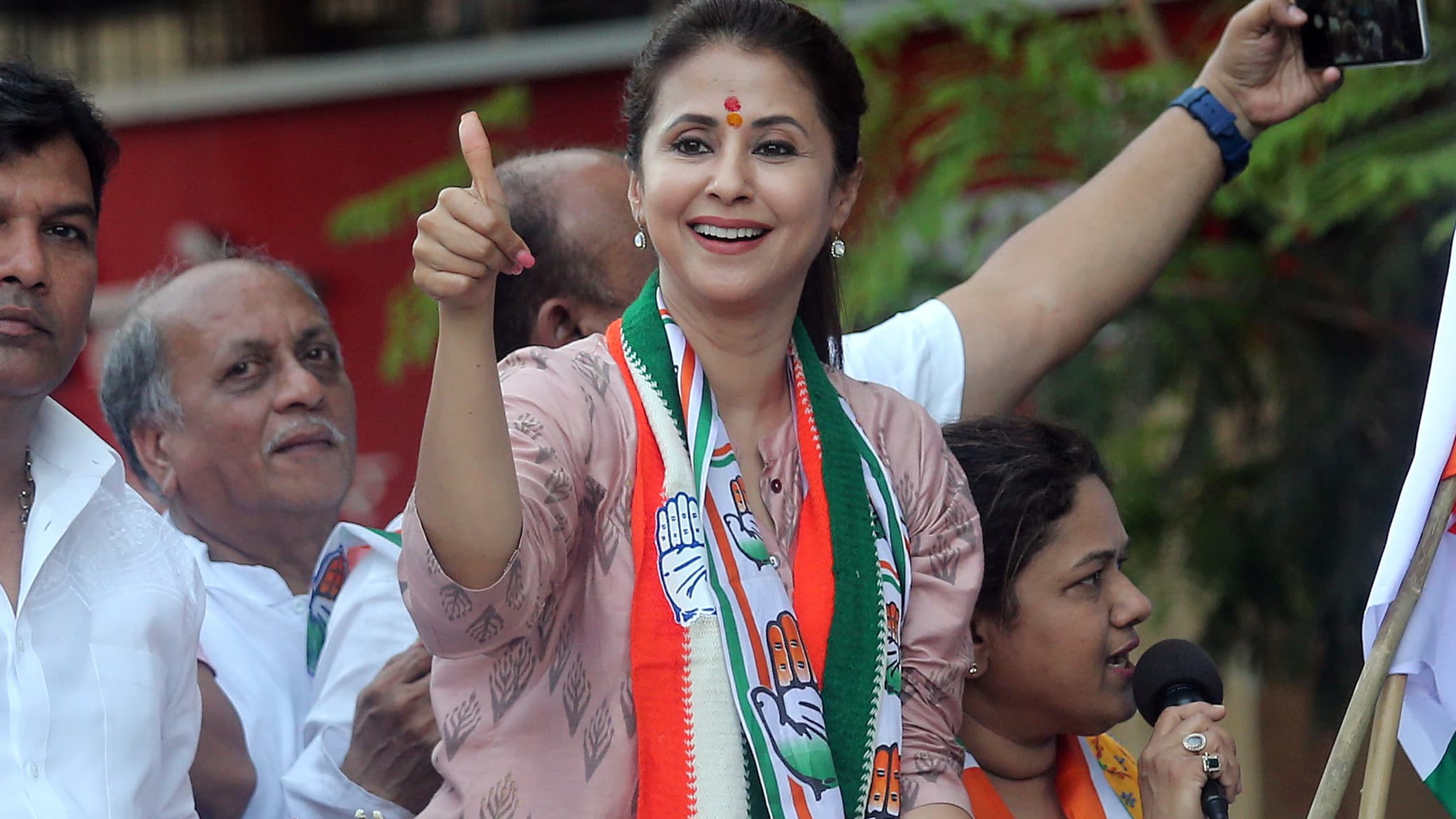 A woman politician gives a thumbs up on back of truck