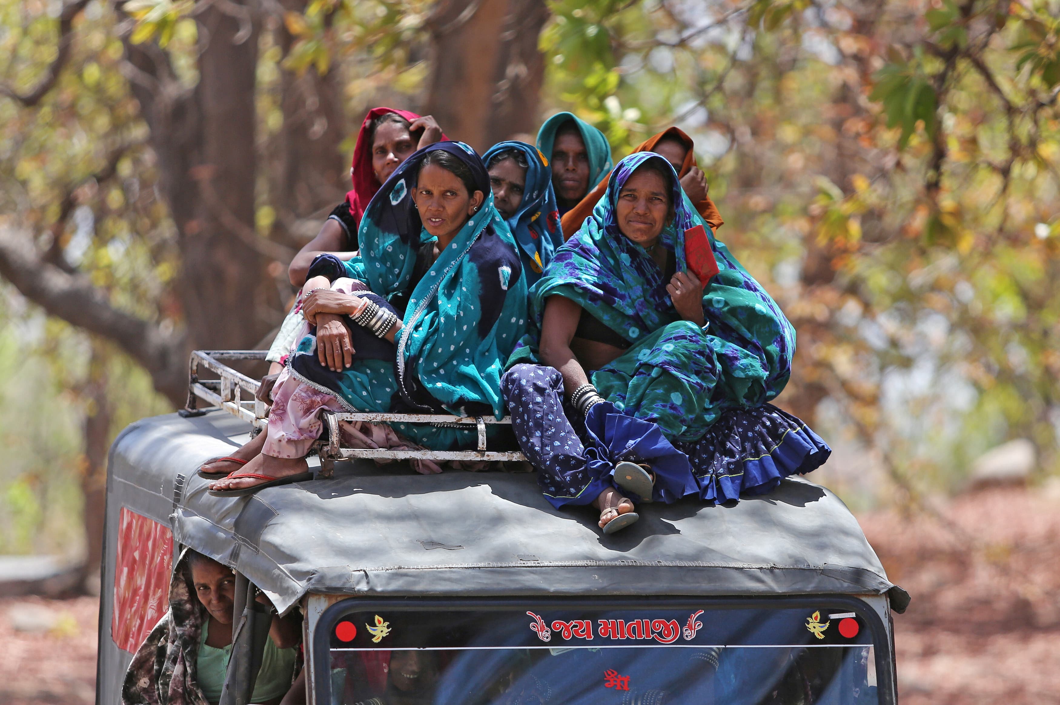 women sit on top of bus after voting