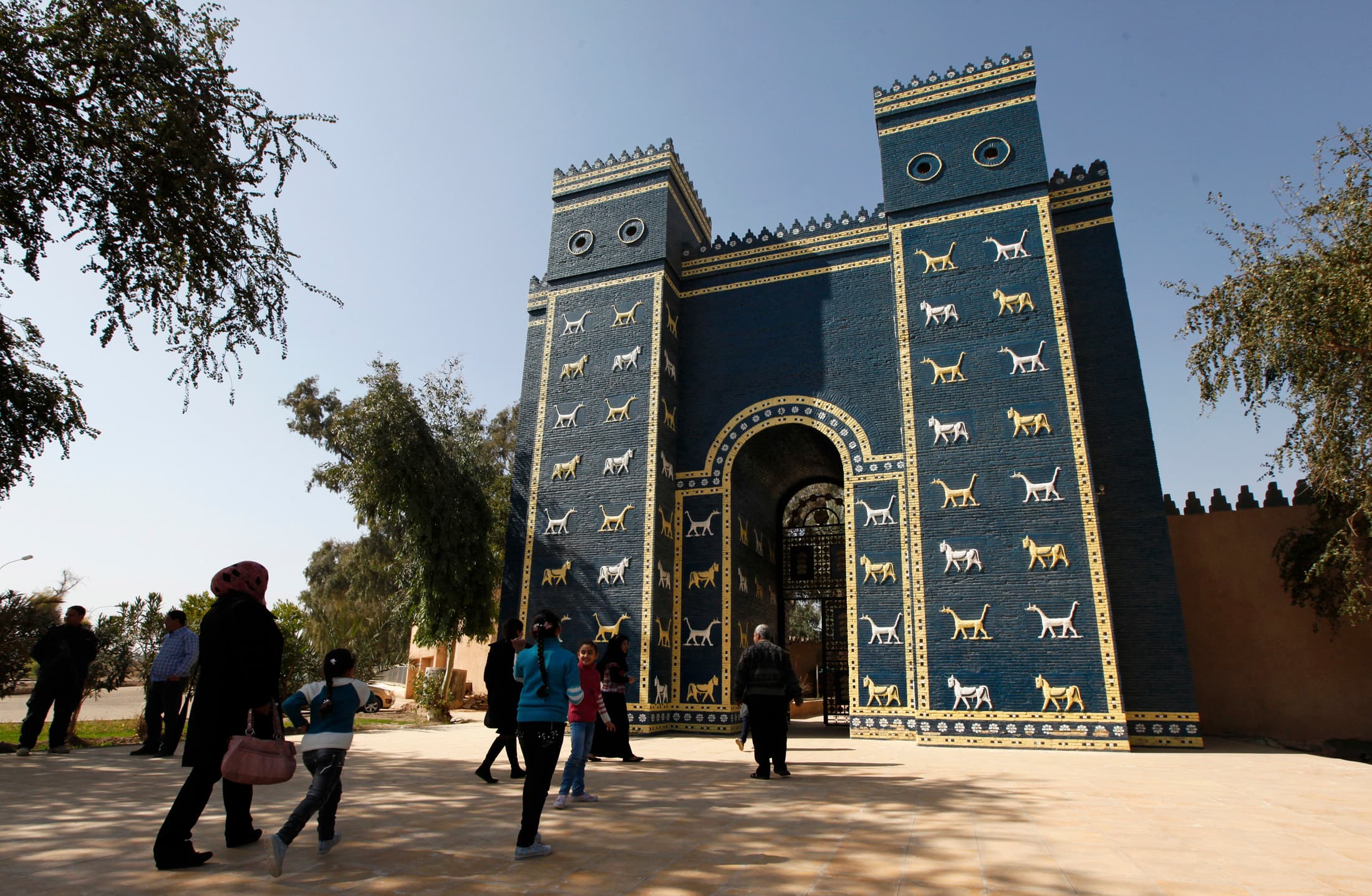 People stand next to a blue gate.