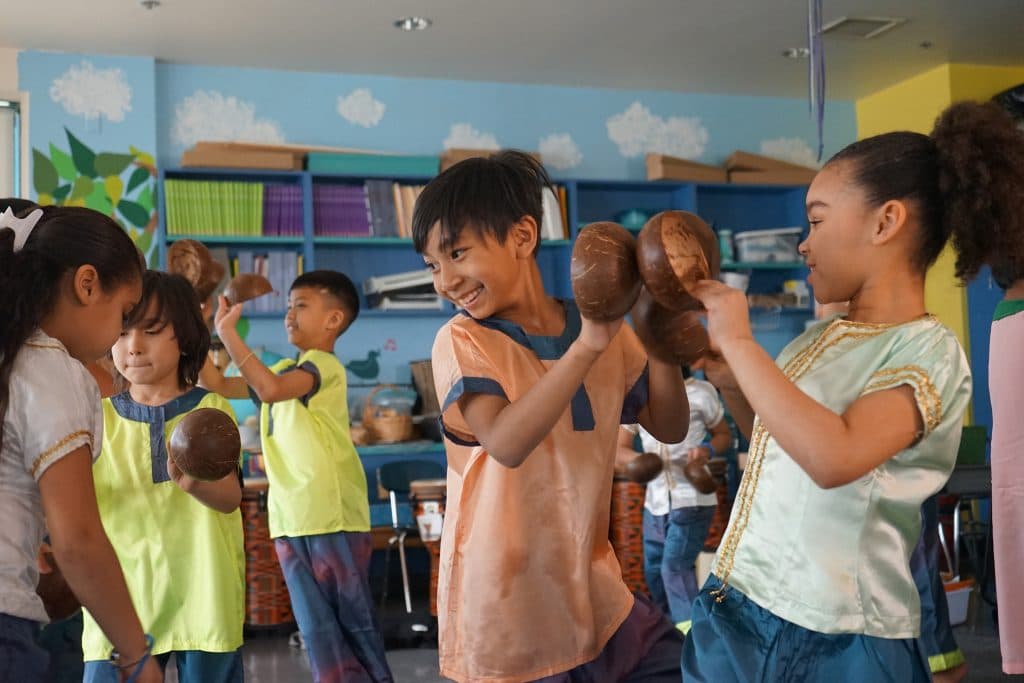 Irish American music teacher Rita Laughlin teaches kids in Lowell, Massachusetts, how to play traditional Cambodian instruments. Here, fourth graders practice the Coconut Dance in costume.