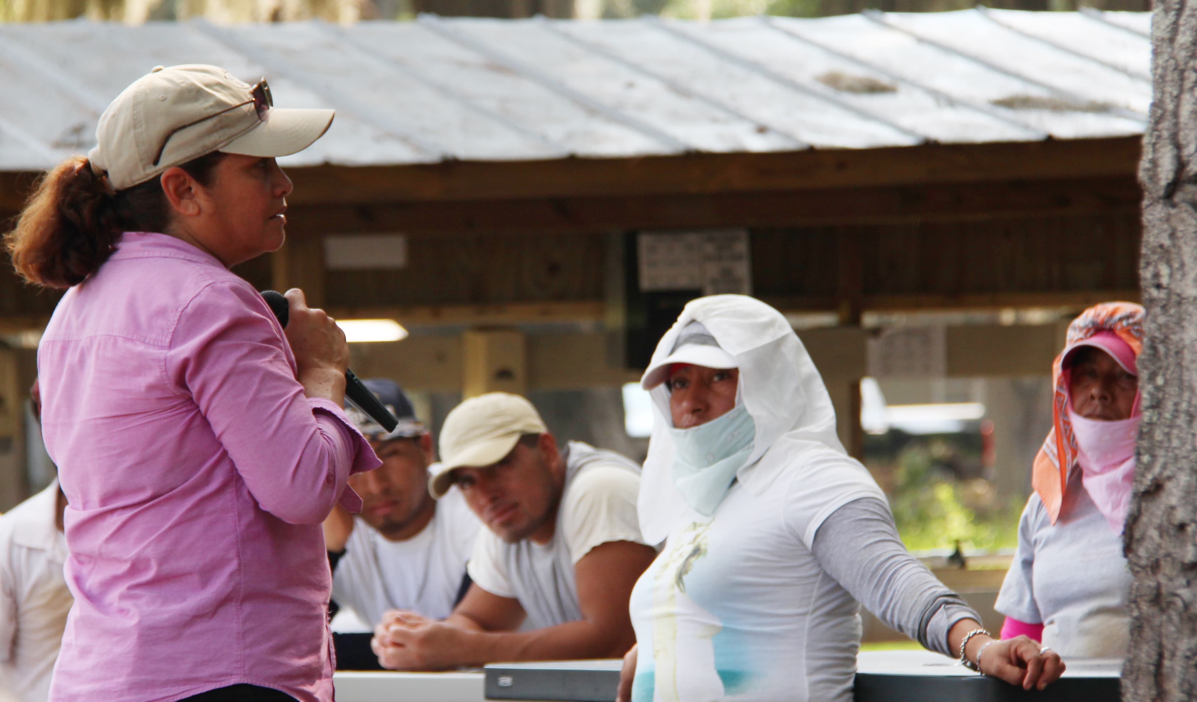 A worker with a microphone educates other workers about their rights