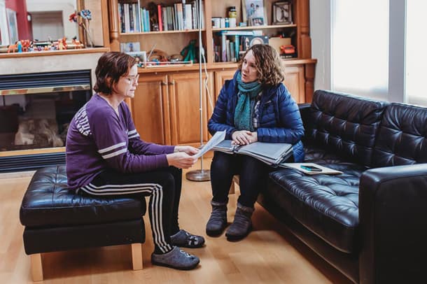 Two woman are shown sitting across from each other.
