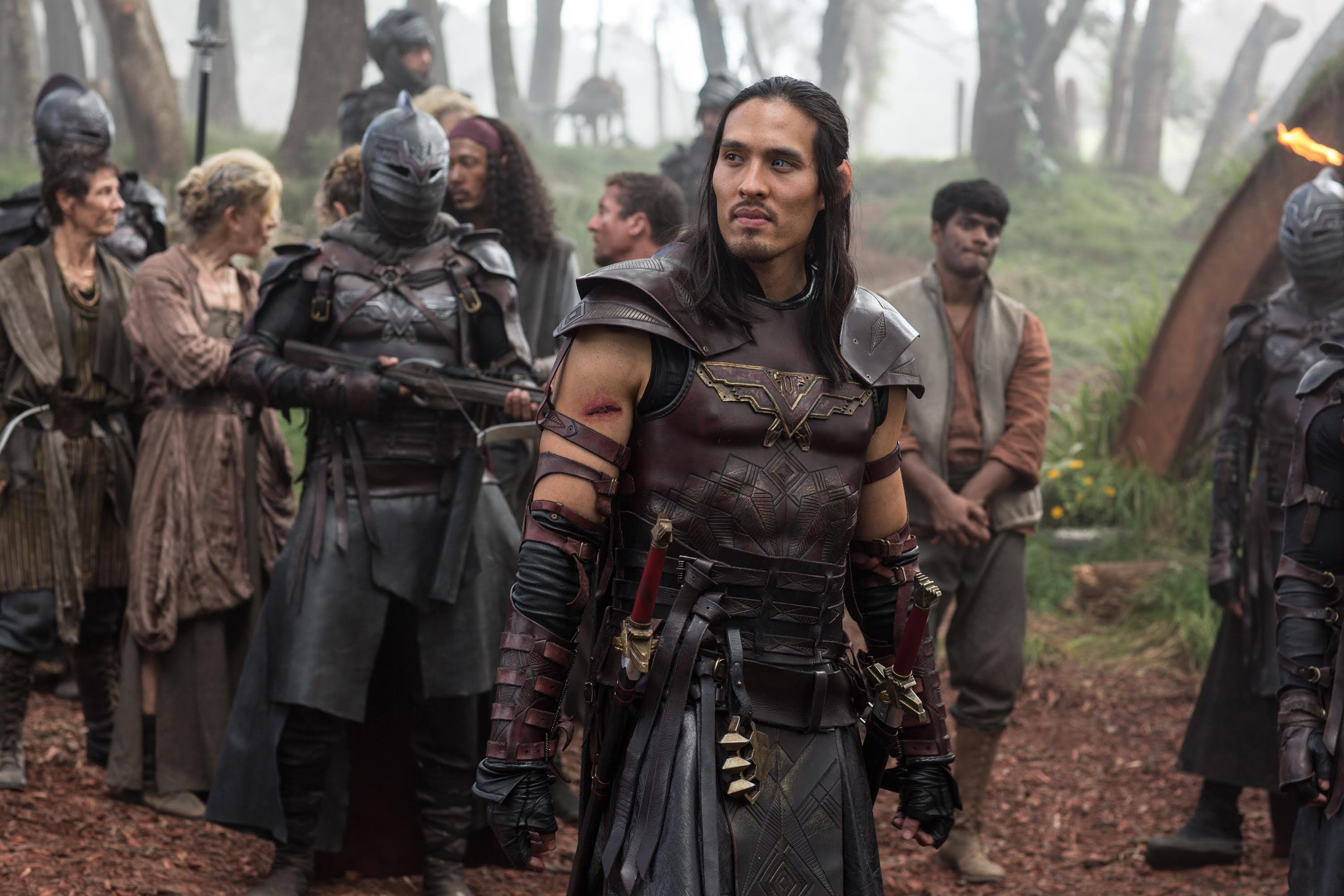 A man in an armor stands alongside other men in armor.