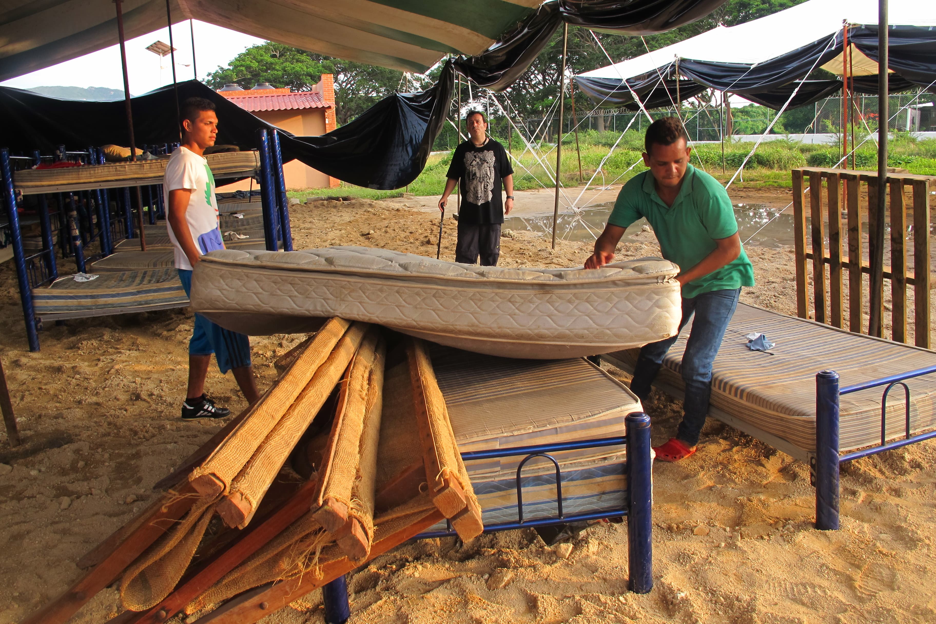 Migrants move beds out of a dormitory badly damaged by the strongest earthquake to hit Mexico in a century into a large tent at the shelter in Ixtepec, Oaxaca.