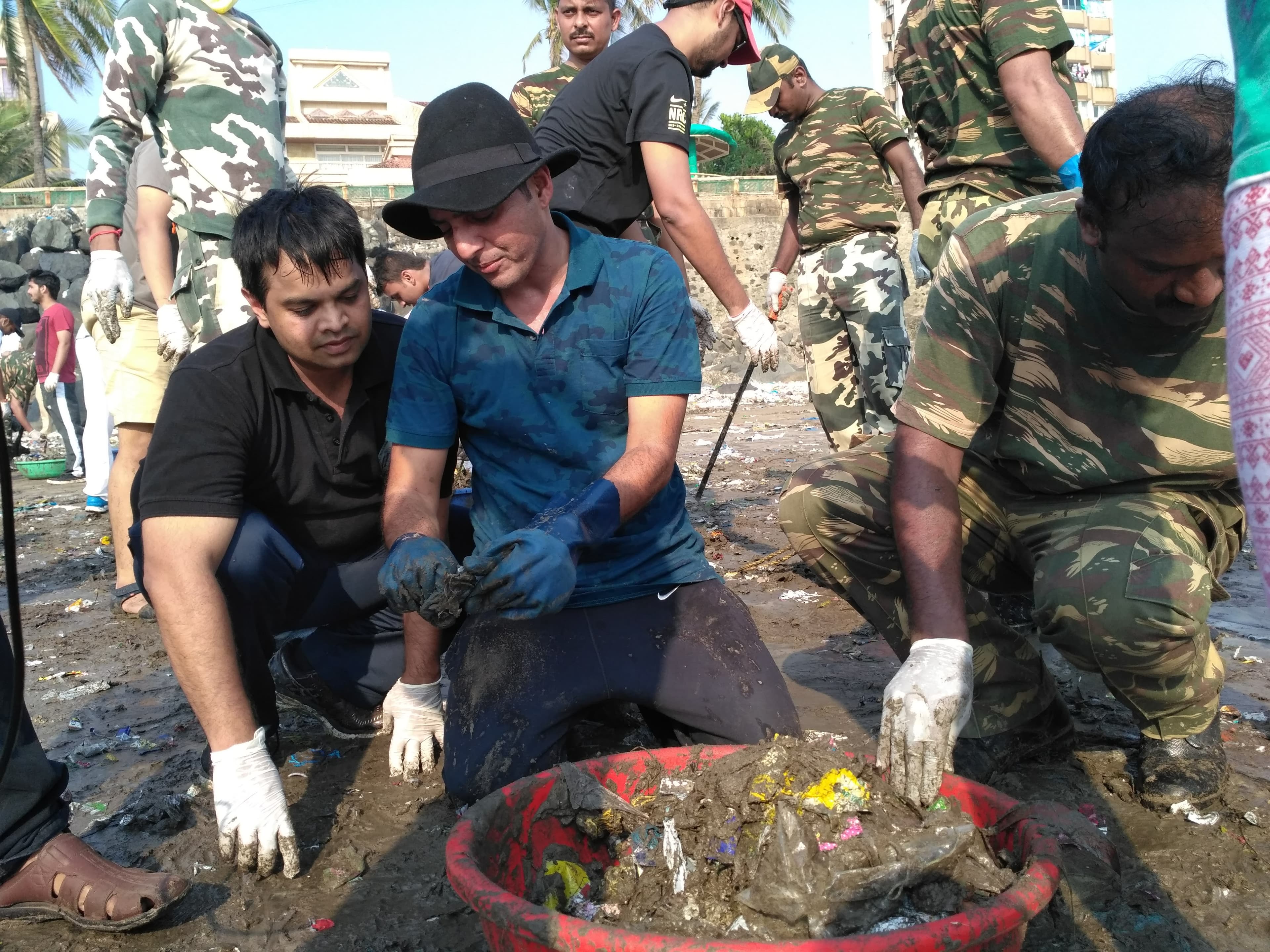 Afroz Shah shows another volunteer what he does with the trash he finds on his beach