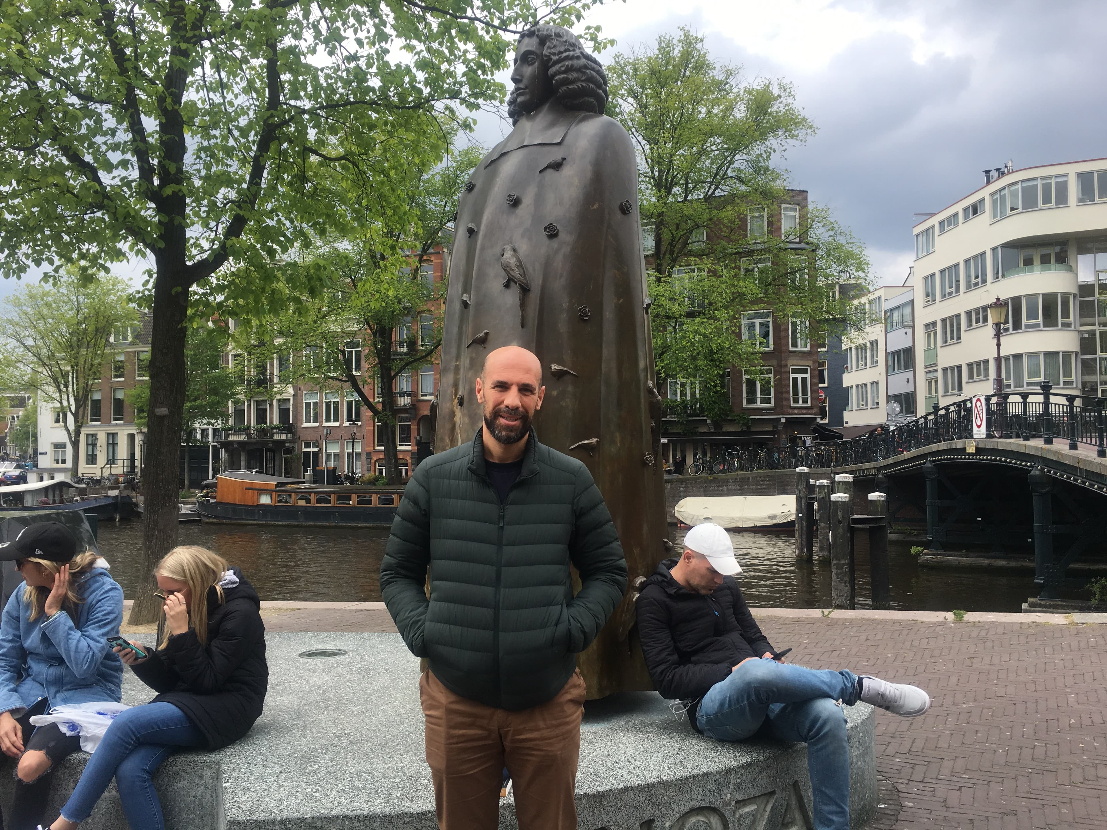 A man stands in front of a statue