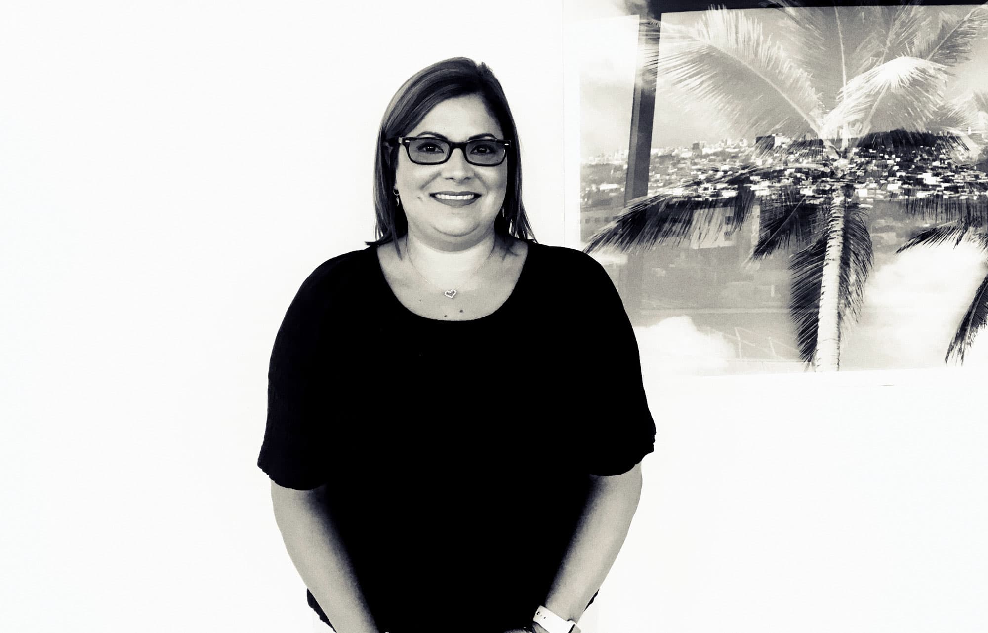 Maria Olivero, a woman with shoulder-length dark hair and eyeglasses, poses for a portrait.