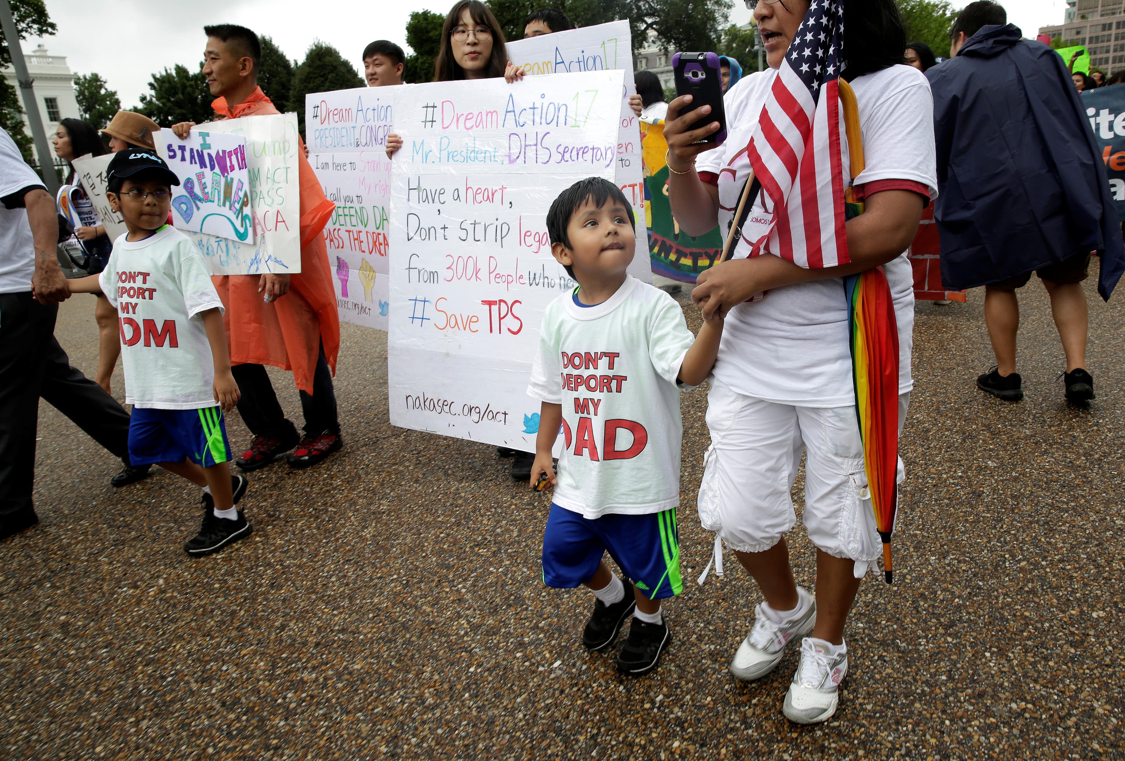 Boys wearing shirts calling for their parents not to be deported march during a rally by immigration activists CASA and United We Dream