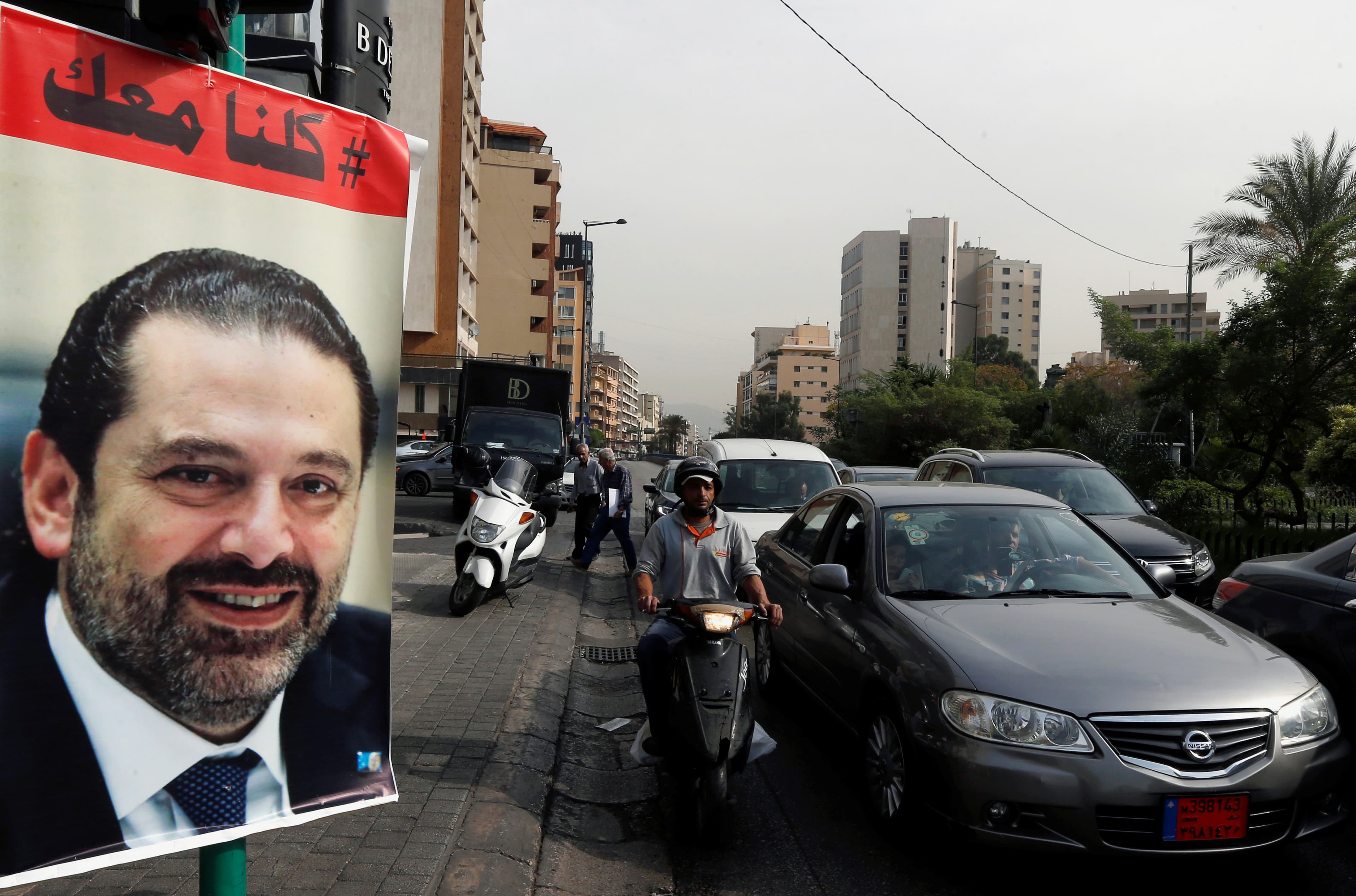 Cars pass next to a poster depicting Saad Hariri, who has resigned as Lebanon's prime minister, in Beirut
