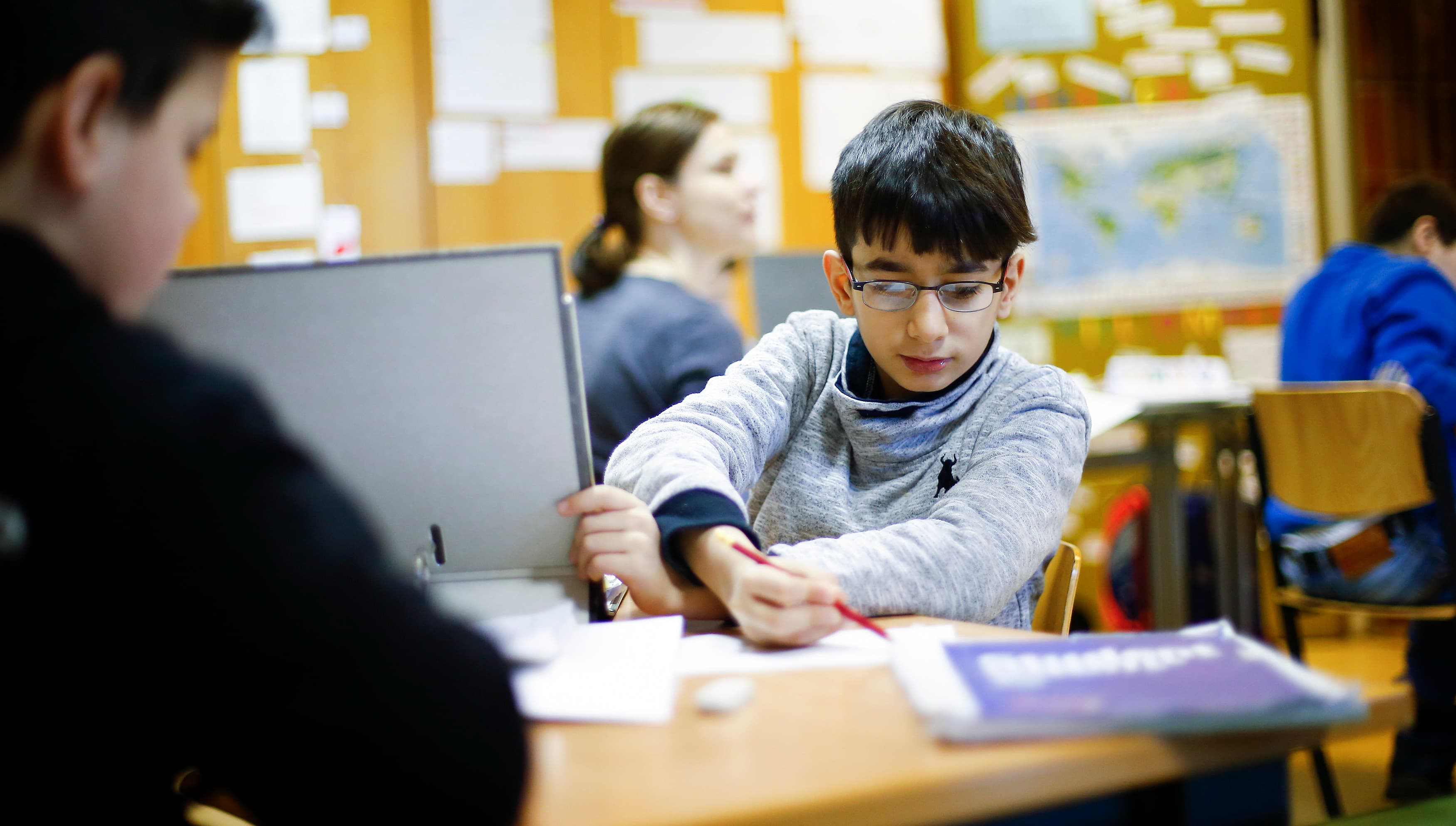 Students in a welcome class for migrants attend a German language lesson at the Sankt Franziskus school in Berlin, Germany, Jan. 22, 2016.