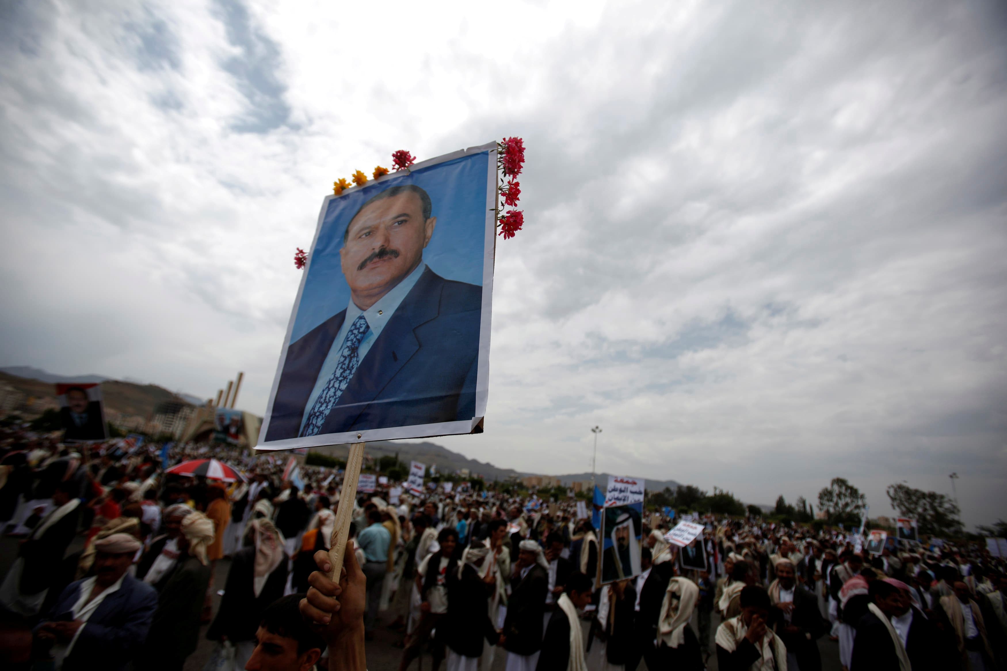 A supporter of Yemen's then President Ali Abdullah Saleh waves a poster featuring him during a rally to show support for him in Sanaa