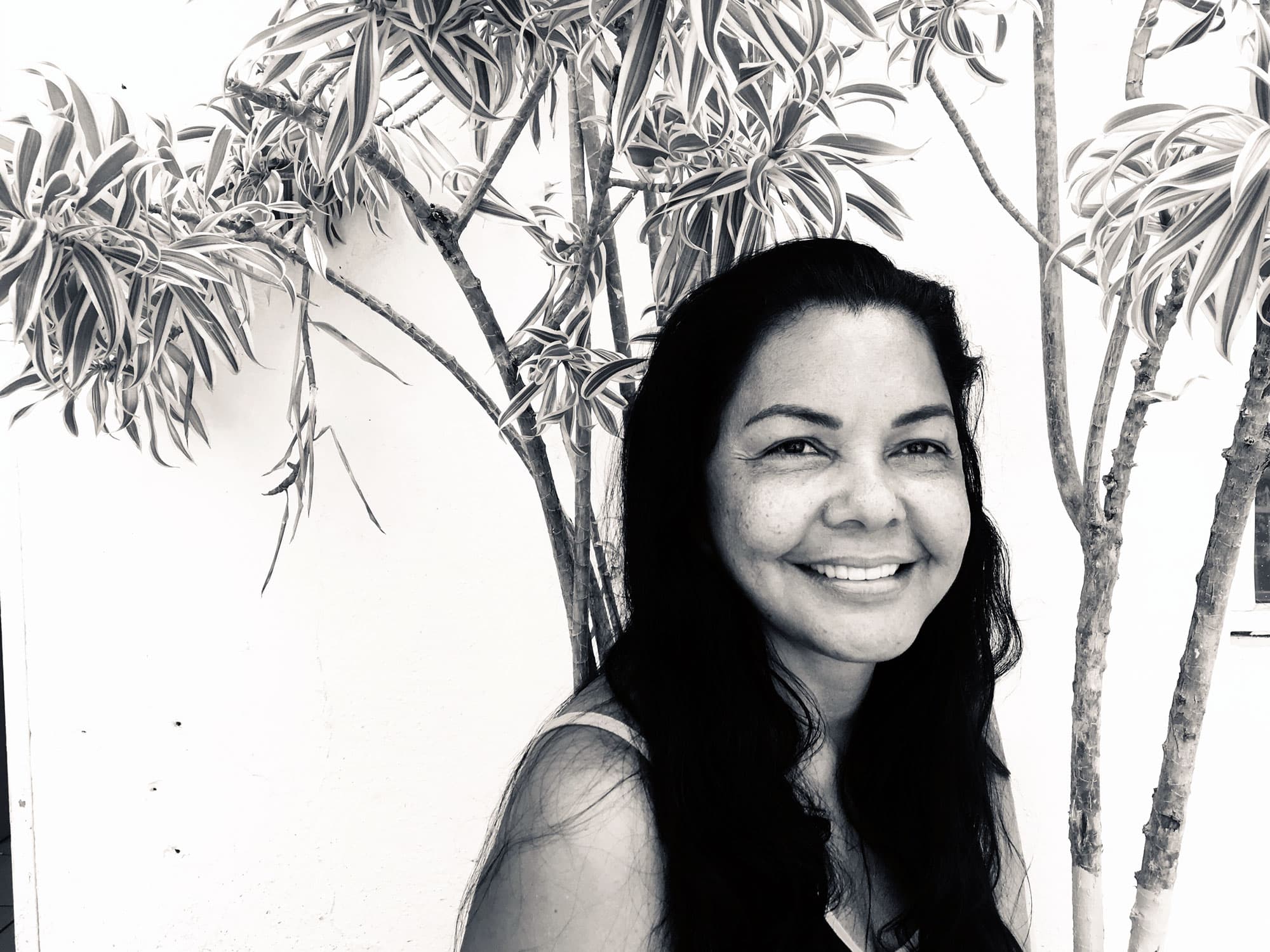 Yolanda Prosper, a woman with long dark, wavy hair, poses for a portrait.