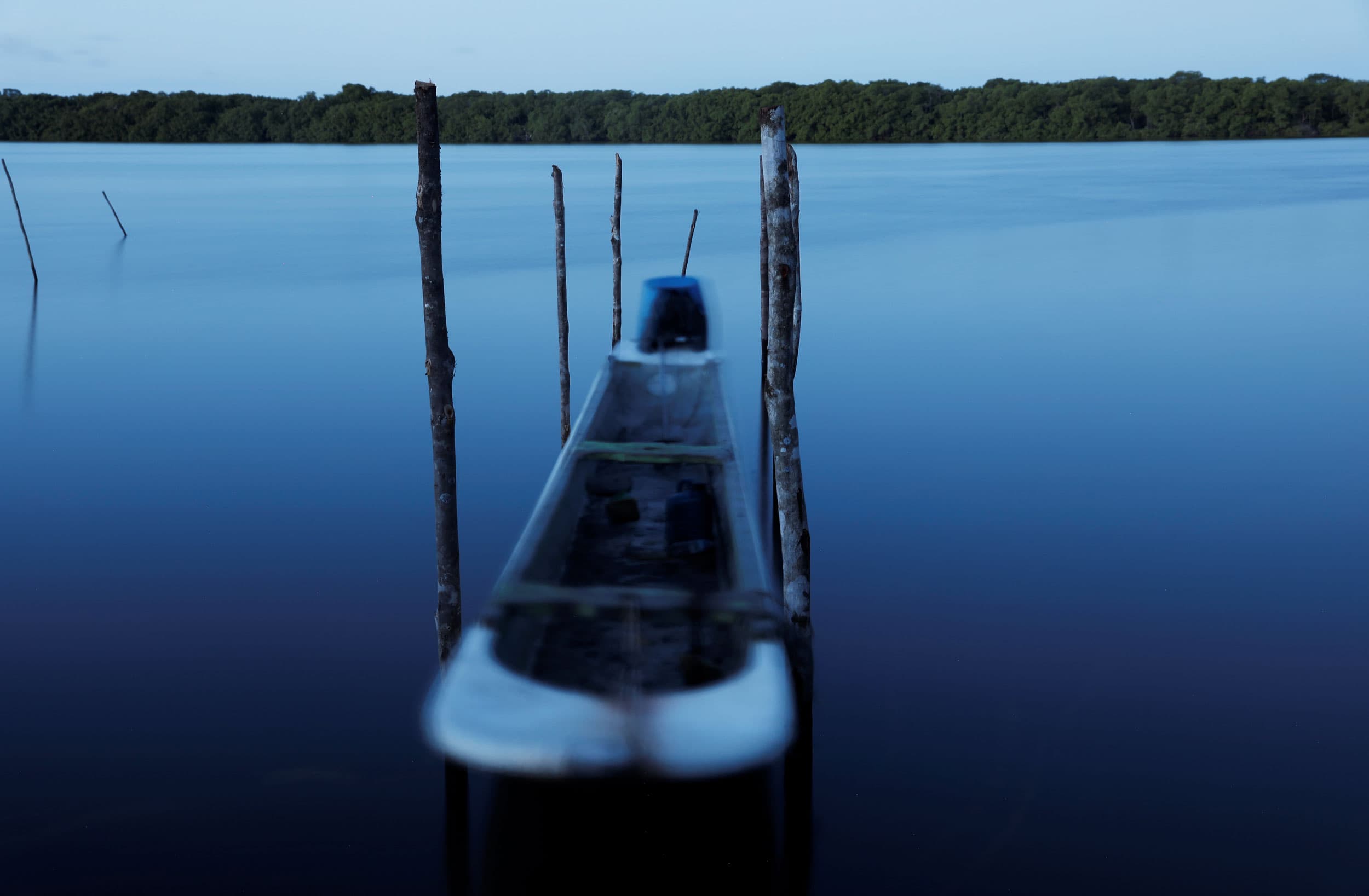 A narrow boat is shown slightly blurred in a long exposure photograph.