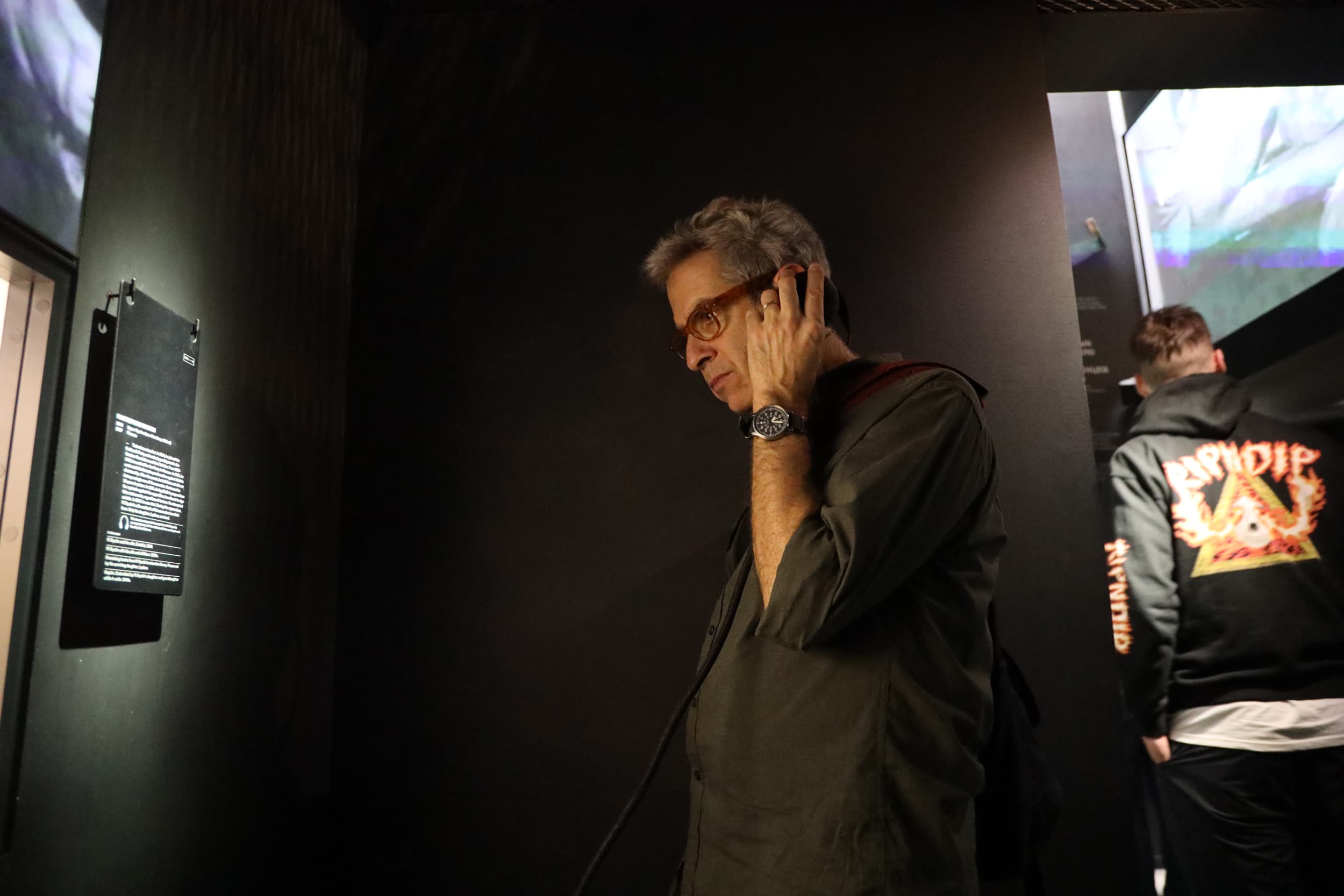 A man stands in a dark museum