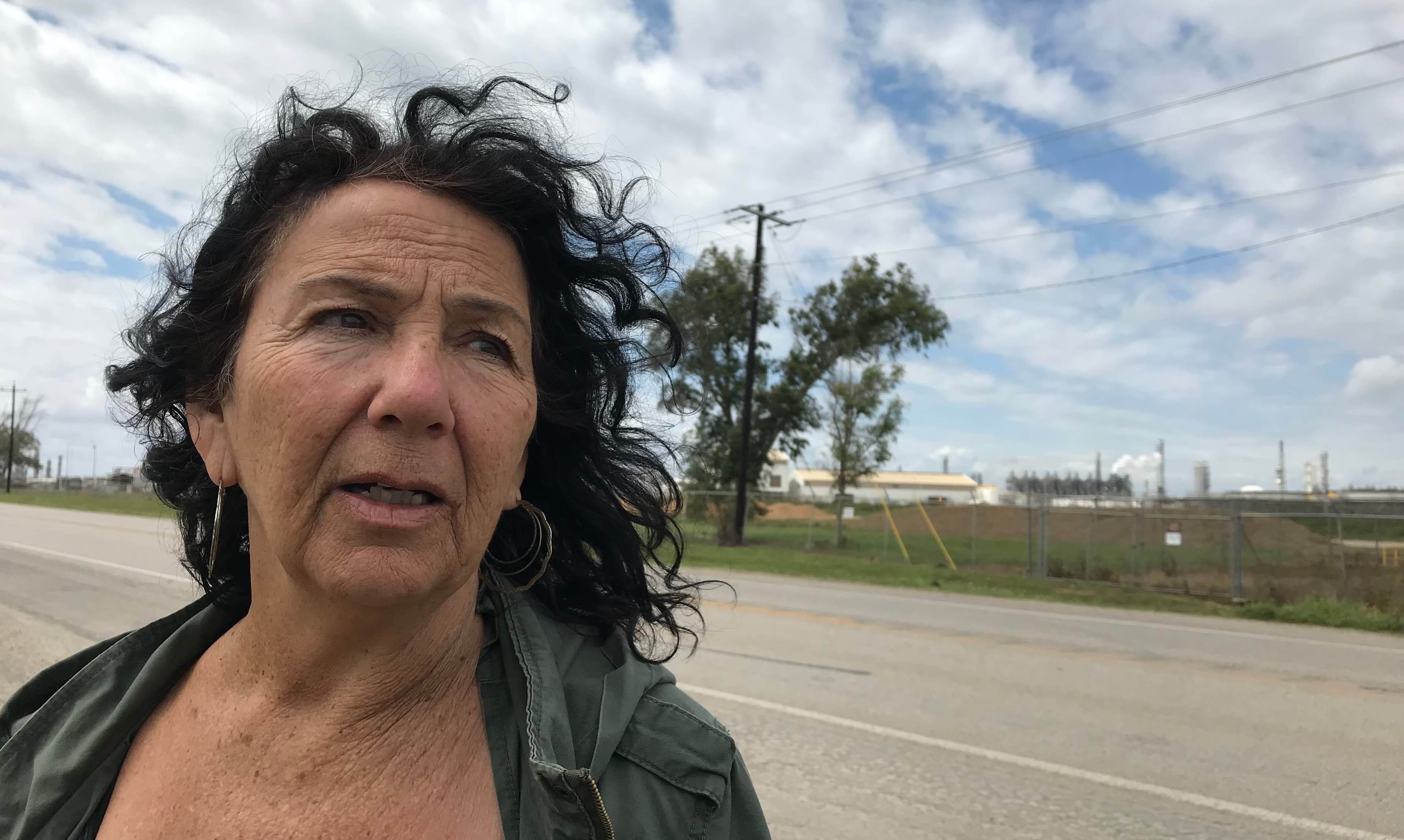 A portrait of a woman standing outside.