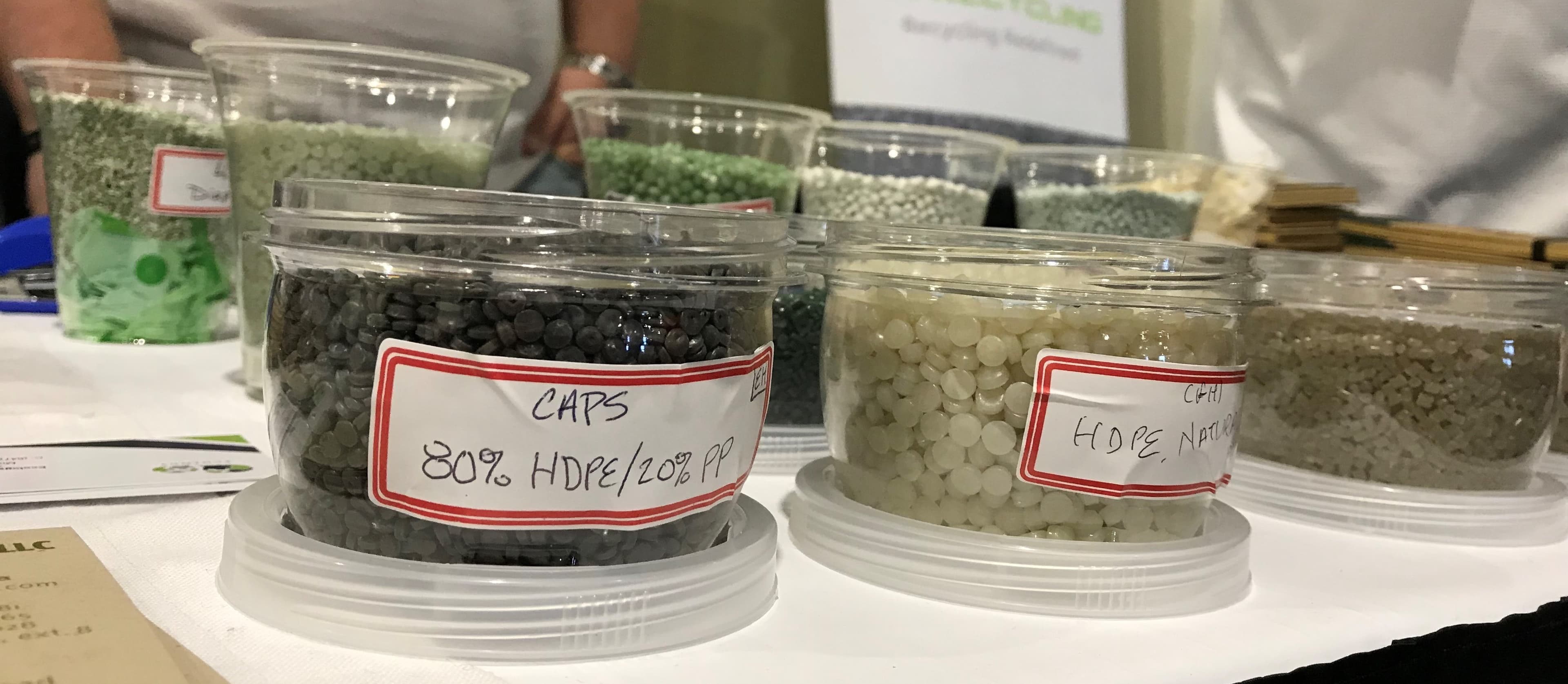 Plastic pellets being held in small containers.