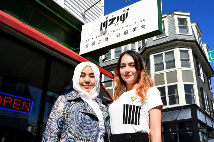 Two women stand outside a restaurant