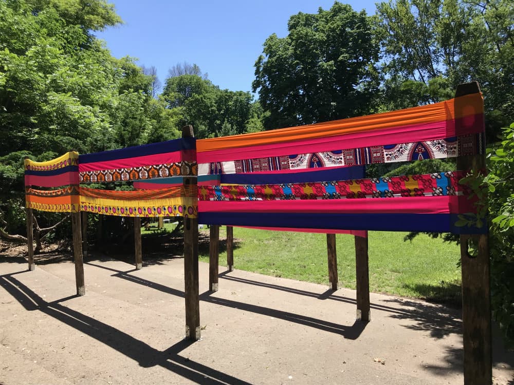 An art installation that includes bright cloth around several posts.