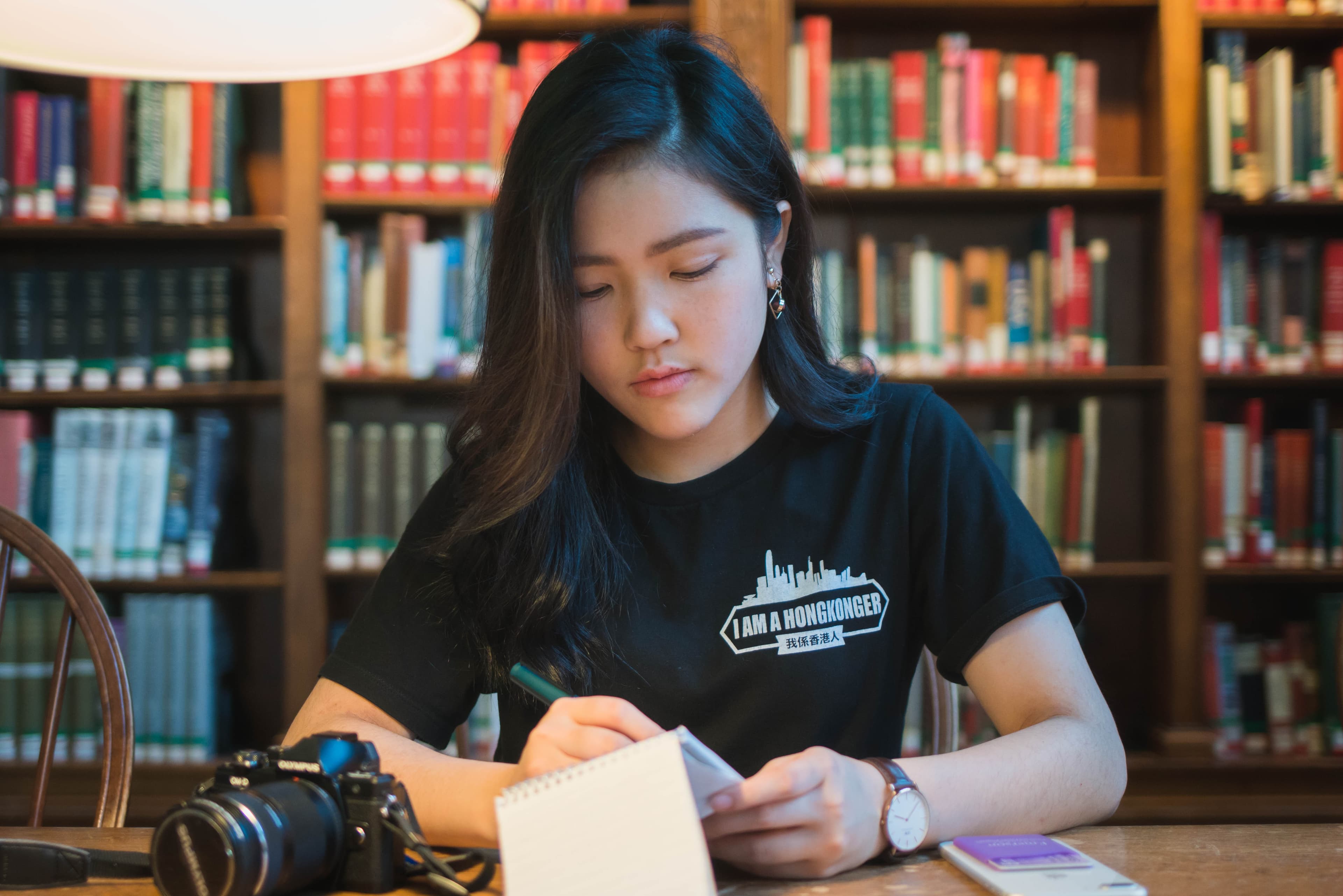 A young woman writing on a notepad
