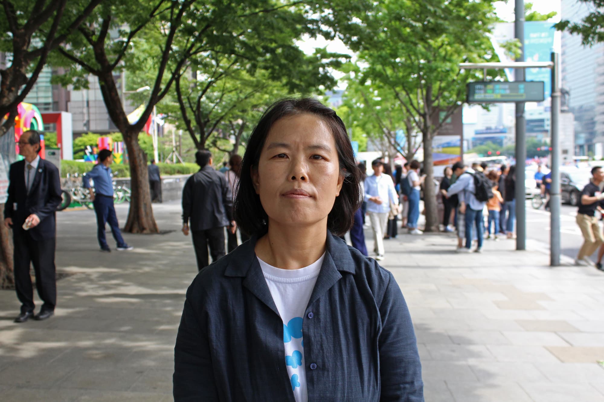 A woman in blue jacket shares her view on the street at a protest.