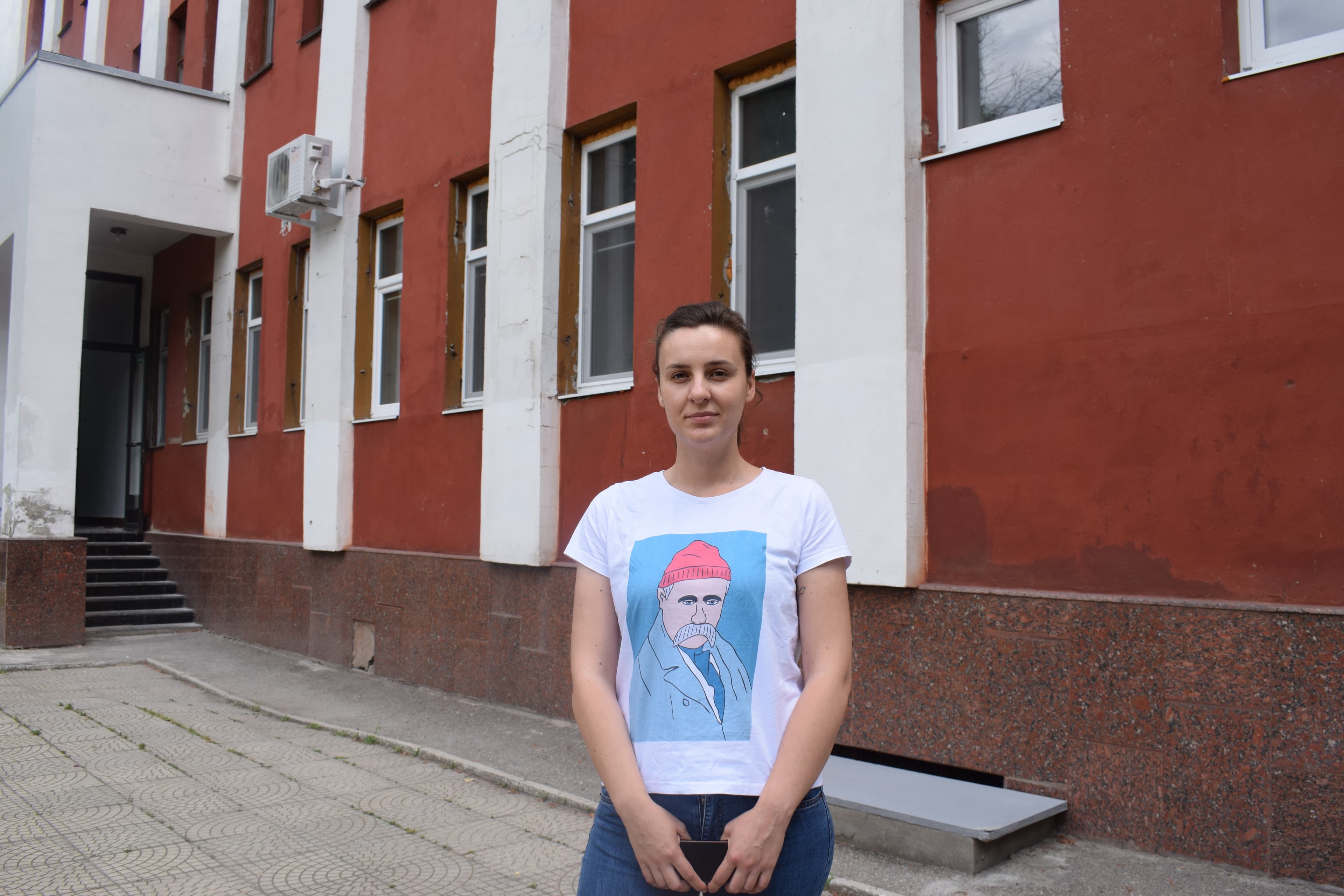 A woman stands near an office