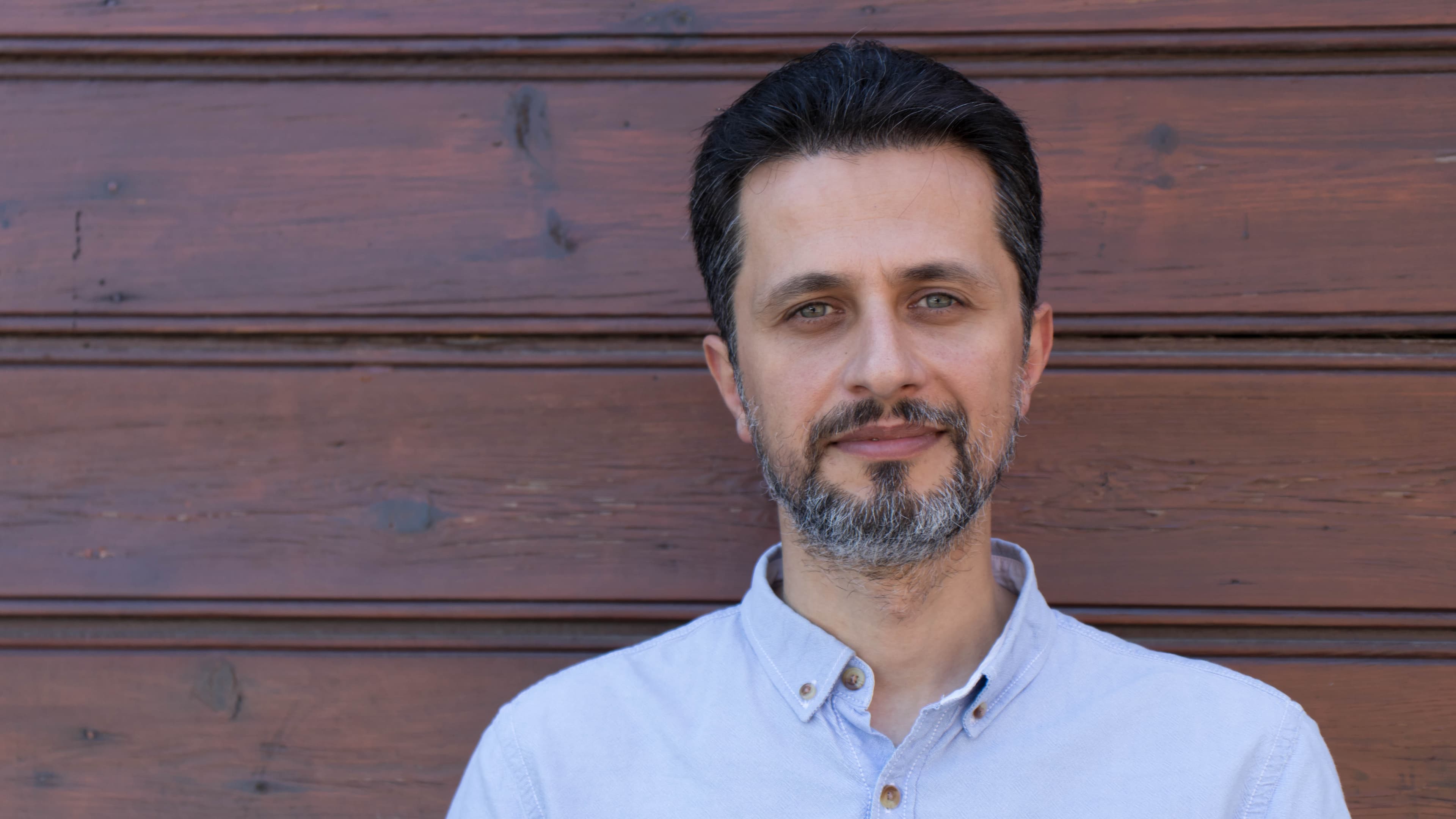 A close up of a man with a light beard wearing a blue shirt