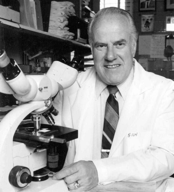 Scientist Burgdorfer at the microscope.