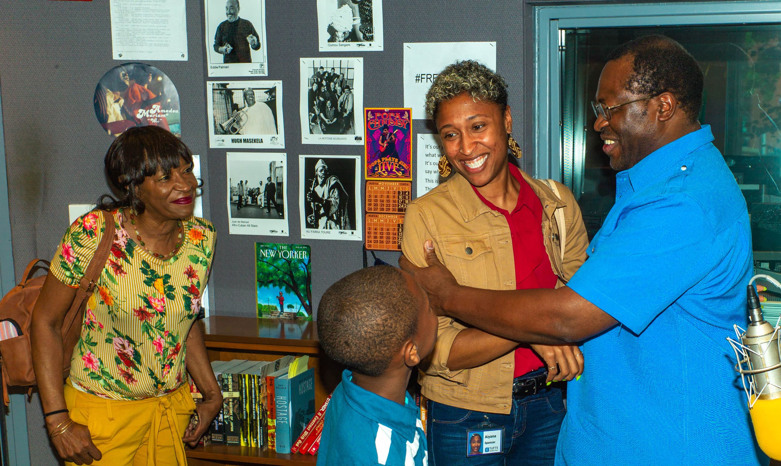 A man and woman hug as a child and another woman look on