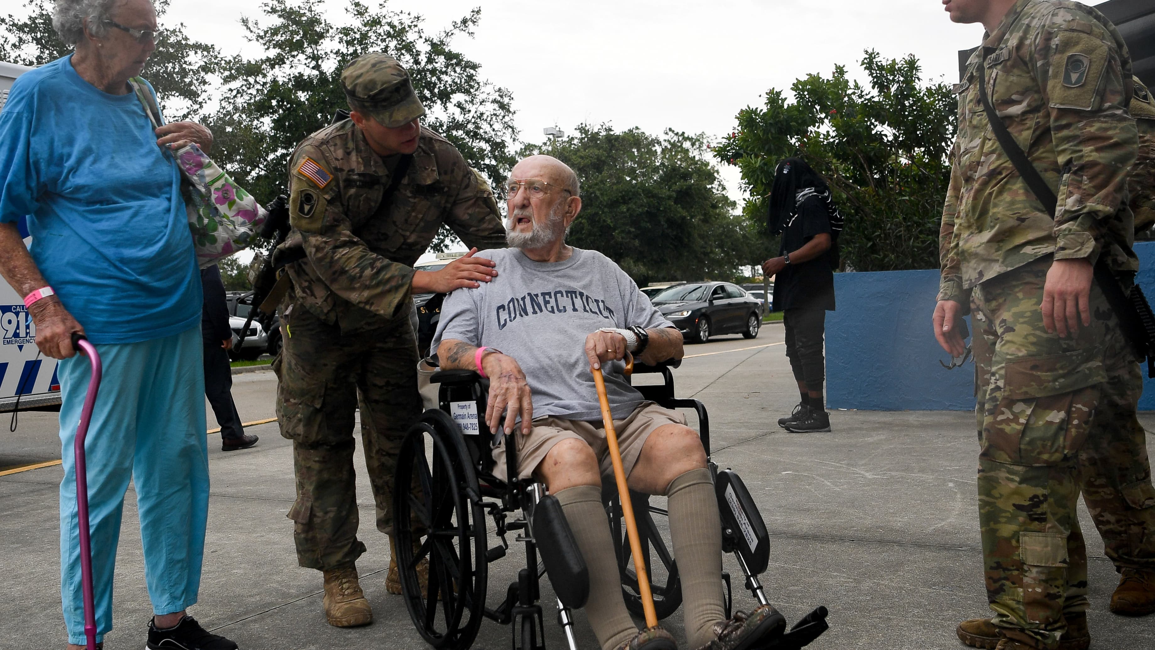 A man in a wheelchair is evacuated during a storm