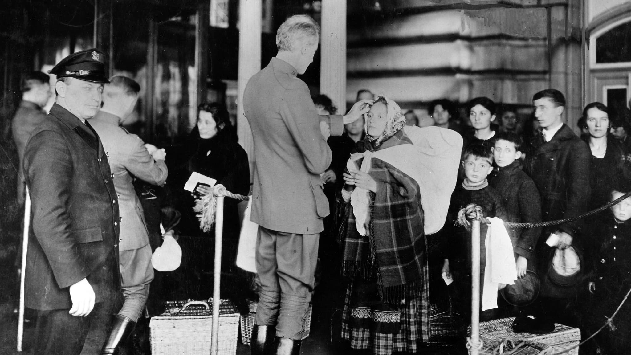 A black and white photo of people going through immigration queues