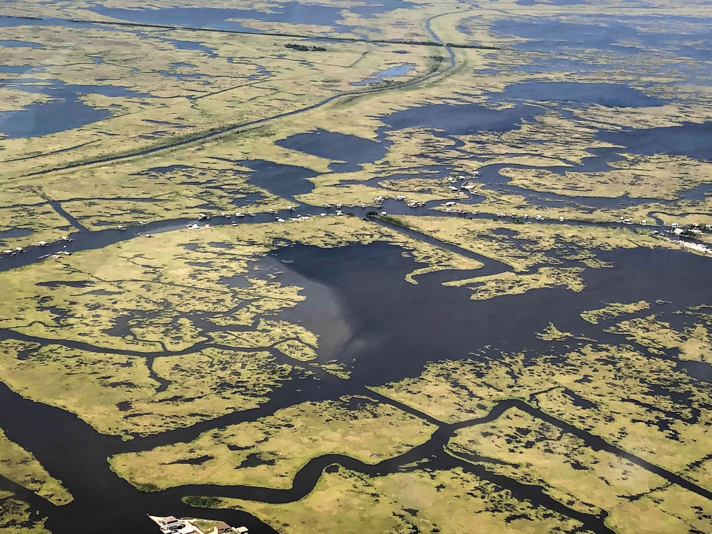 Several houses are shown from above in an airplane with very little land for the houses to sit on.